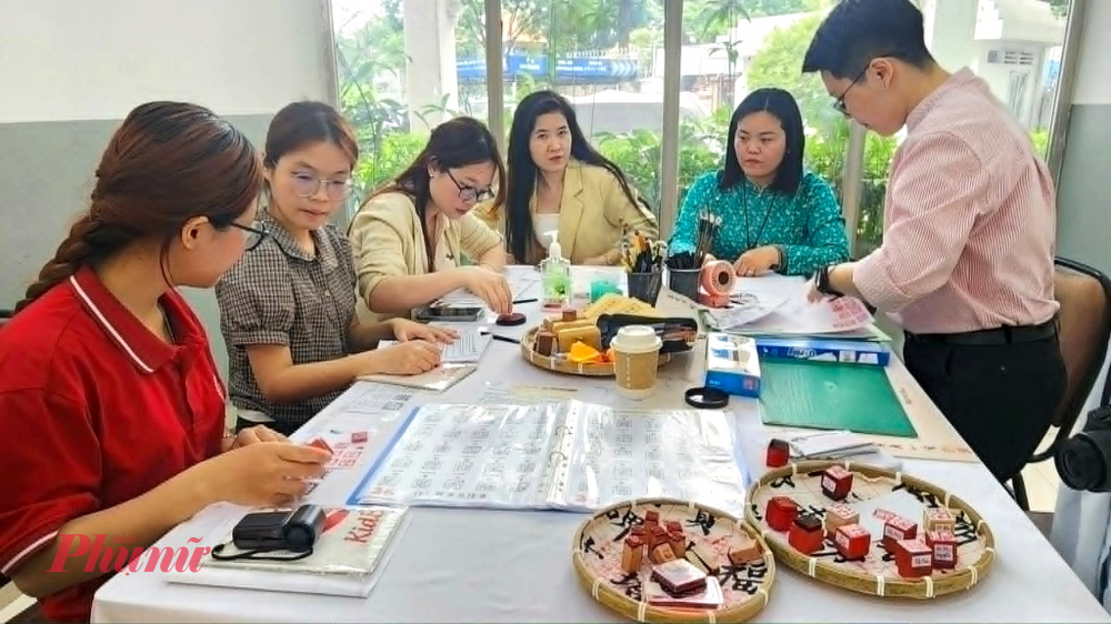 Các bạn sinh viên và khách tham dự trải nghiệm hoạt động khắc triện trong khuôn khổ chương trình giao lưu văn hóa