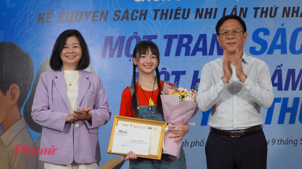 Phó giám đốc Sở Văn hóa và Thể thao TPHCM Nguyễn Ngọc Hồi (bìa phải) và Tổng biên tập Báo Phụ Nữ TPHCM (bìa trái) trao giải Khuyến đọc - 