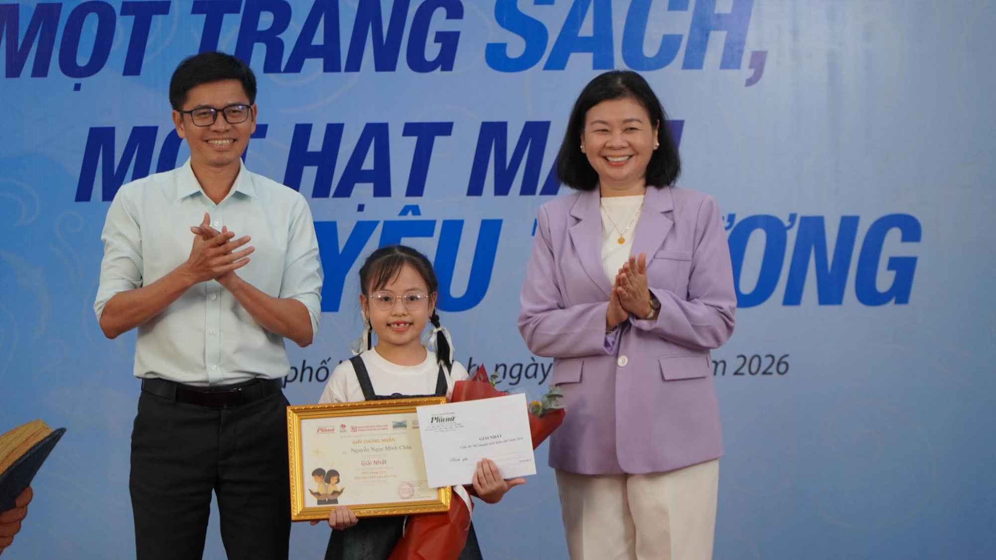 Bà Lý Việt Trung – Tổng biên tập báo Phụ Nữ TPHCM và ông Trần Đình Ba - Phó Giám đốc, Phó Tổng biên tập NXB Tổng Hợp TPHCM trao giải Nhất cho bé Nguyễn Ngọc Minh Châu. Ảnh: Hồng Nga
