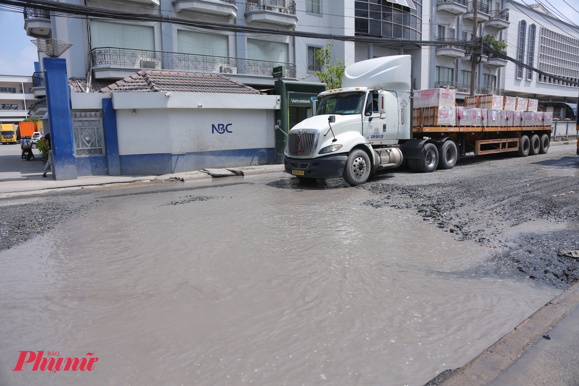 Hố sâu đọng nước trước đầu xe container trên đường Bến Nghé - Ảnh: Nguyễn Văn