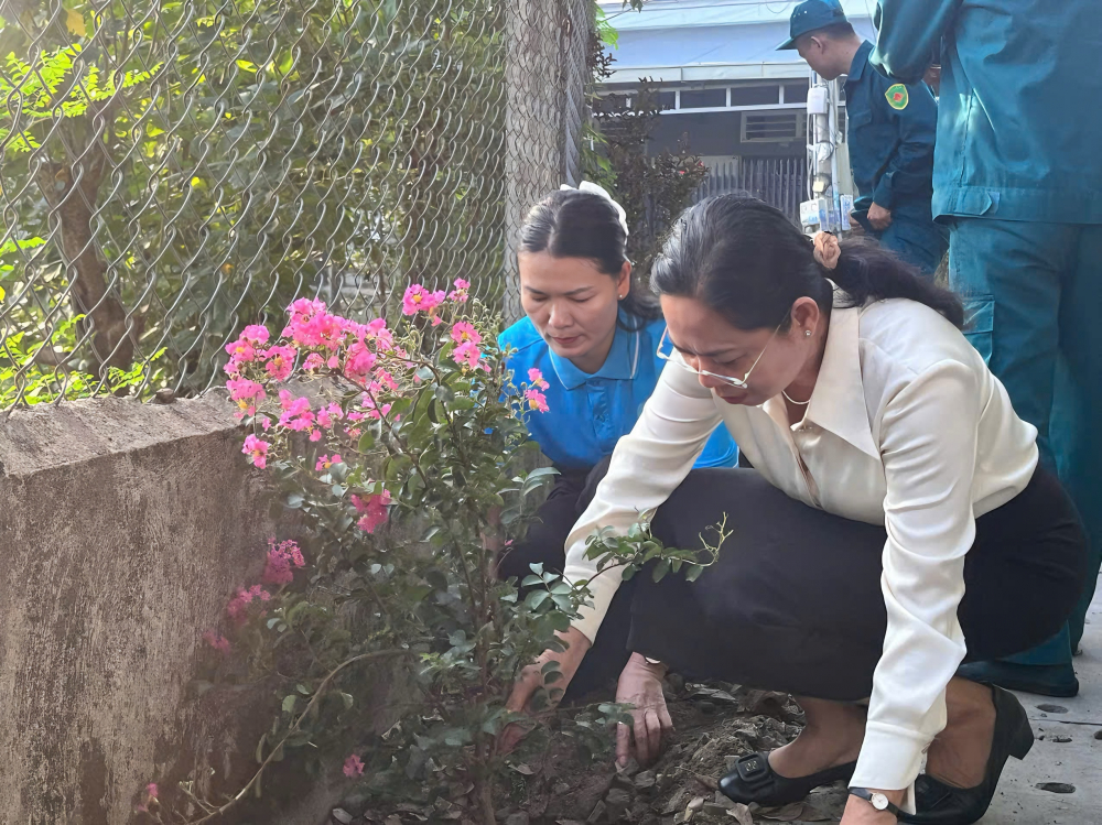 Lãnh đạo phường Phú Lợi trồng hoa quanh tuyến đường. Ảnh: TL