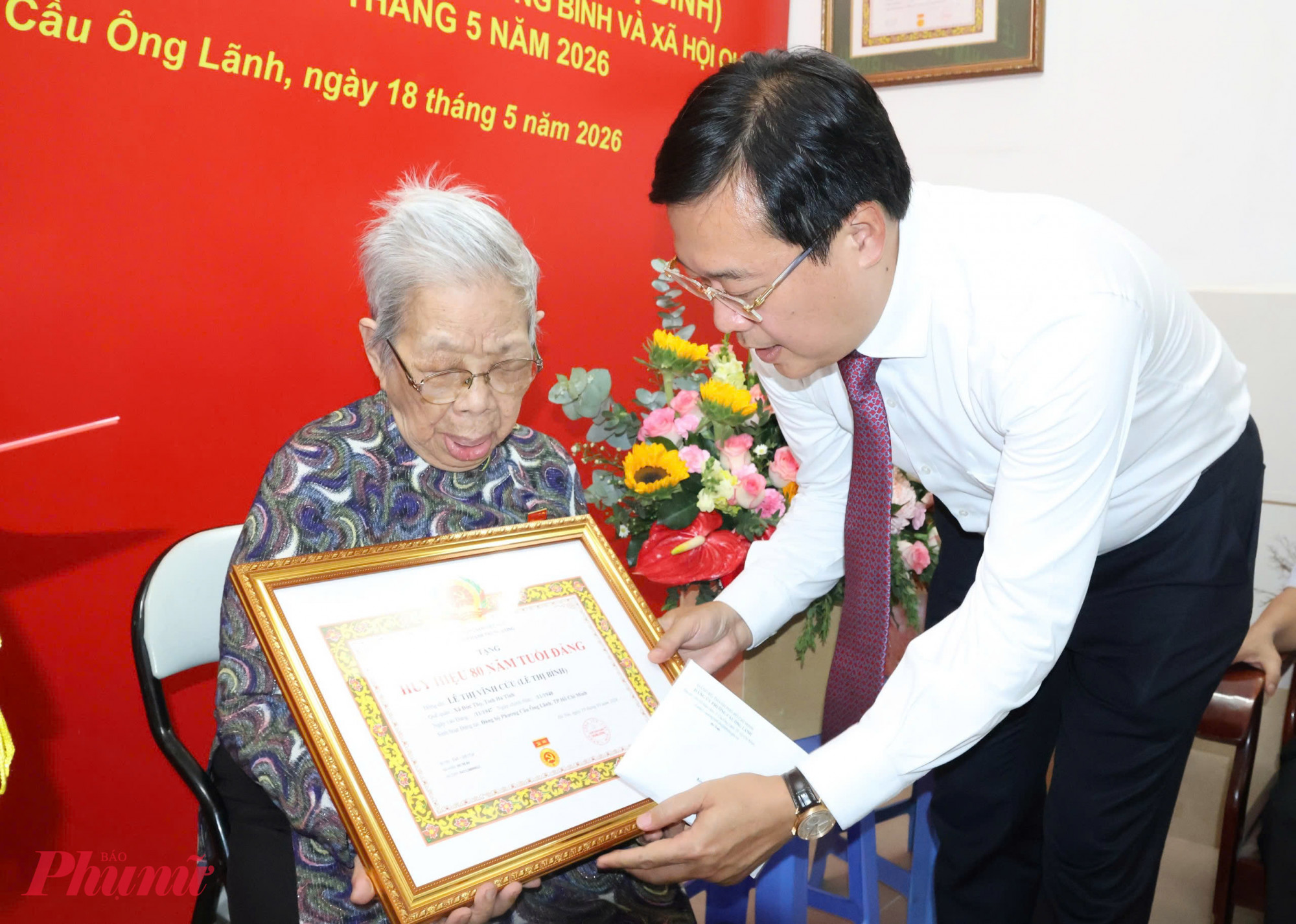 Phó bí thư Thường trực Thành ủy TPHCM Lê Quốc Phong trao Huy hiệu 80 năm tuổi Đảng cho đảng viên Lê Thị Vĩnh Cửu chiều 18/5 - Ảnh: Thanh Tâm