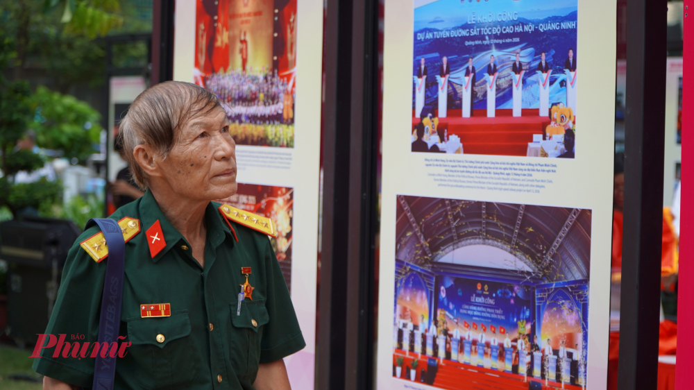 Cựu chiến binh tham quan khu vực triển lãm ảnh, tìm hiểu về cuộc đời và sự nghiệp cách mạng của Chủ tịch Hồ Chí Minh.