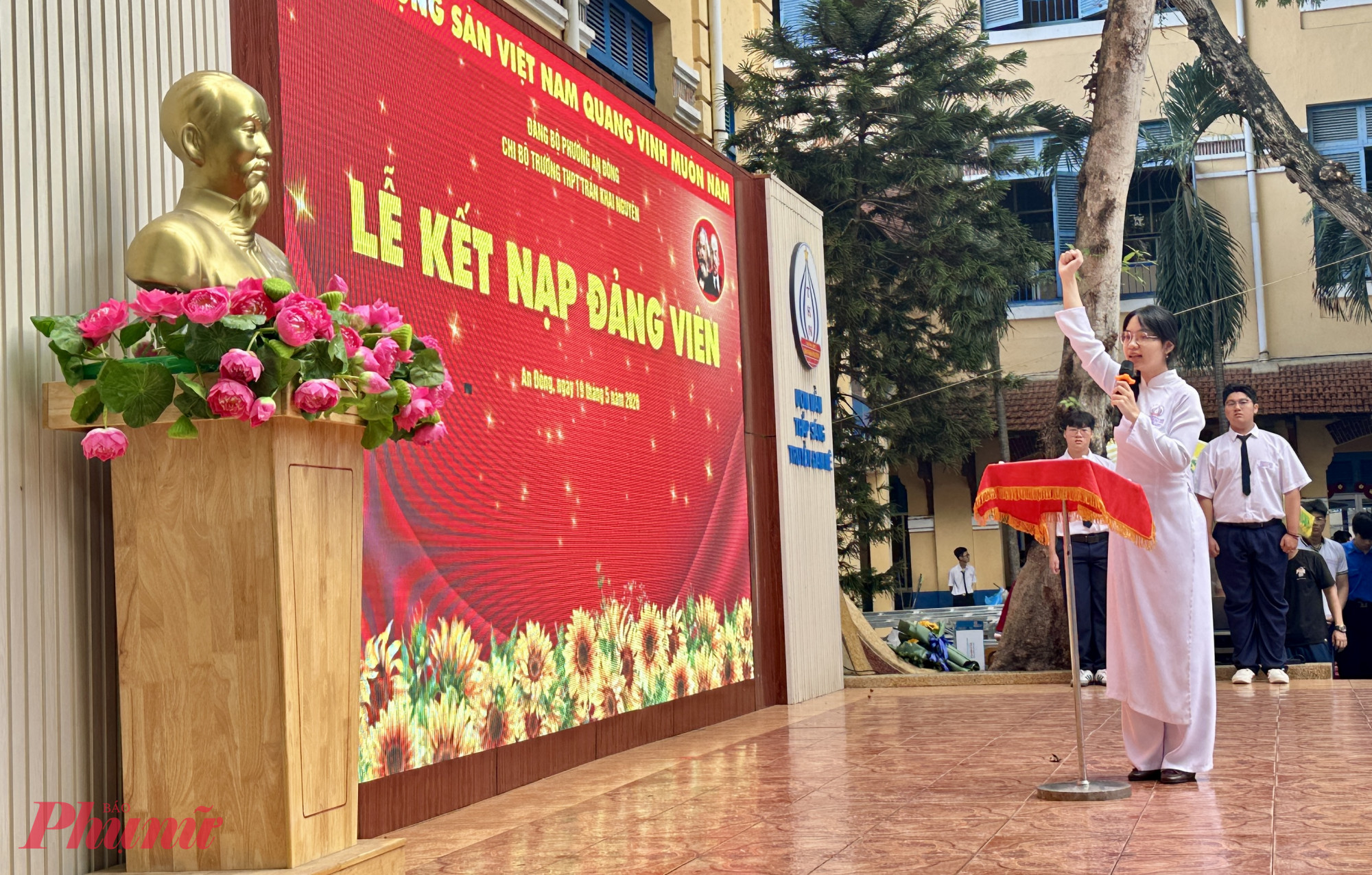 Em La Mỹ Huyền, lớp 12A1 đọc thực hiện nghi thức tuyên thệ dưới cờ Đảng, cờ Tổ quốc và chân dung Chủ tịch Hồ Chí Minh 