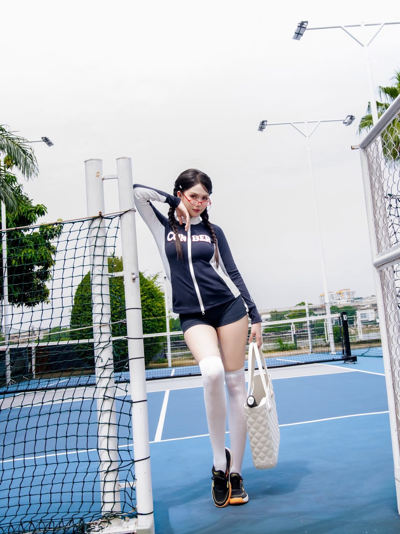 Một trong những hình ảnh gây chú ý nhất là loạt outfit lấy cảm hứng sporty girl trên sân pickleball. Ngọc Trinh diện áo khoác ôm sát phối quần short ngắn, đi cùng tất cao cổ và sneaker. Dù vẫn khoe đôi chân thon dài – lợi thế hình thể quen thuộc của cô – nhưng tổng thể mang tinh thần khỏe khoắn thay vì gợi cảm quá mức.