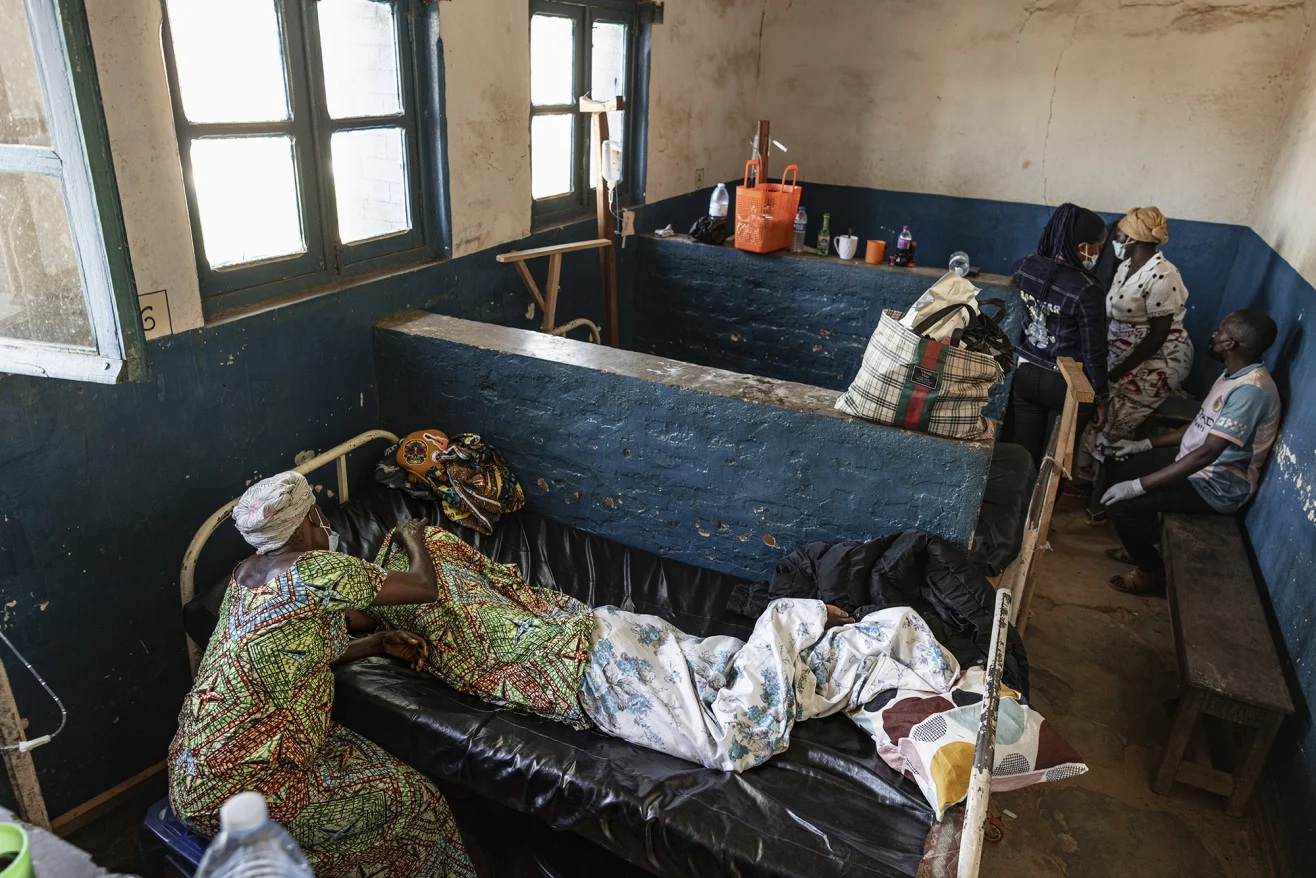 Một người phụ nữ ngồi cạnh người thân được cho là đã tử vong vì Ebola tại Bệnh viện Đa khoa Mongbwalu ở tỉnh Ituri, Cộng hòa Dân chủ Congo - Ảnh: Michel Lunanga/Getty Images