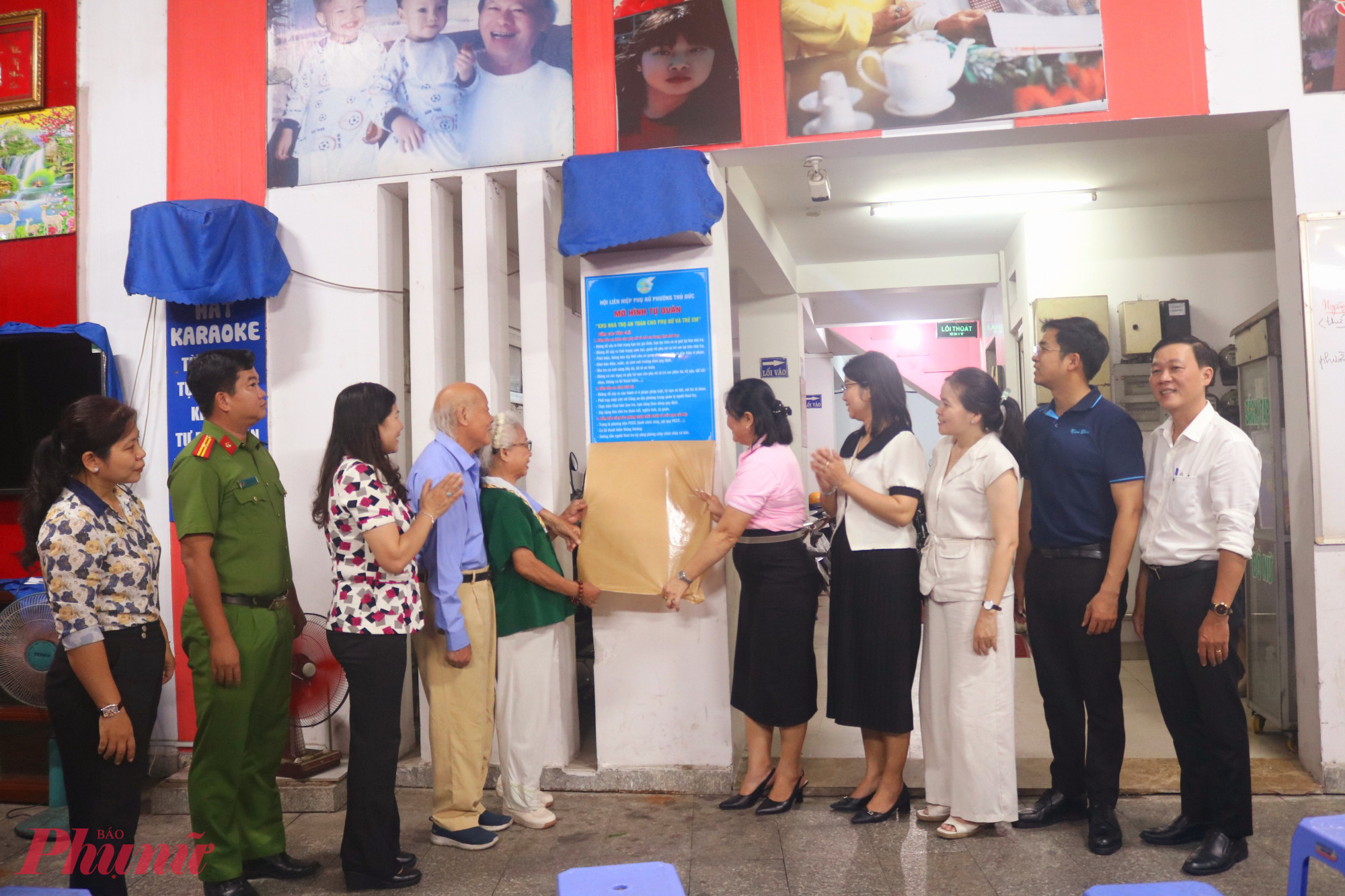 Đại biểu gỡ bảng thông tin các tiêu chí xây dựng “Khu nhà trọ an toàn cho phụ nữ và trẻ” được gắn tại khu nhà trọ số 50 Đặng Văn Bi - Ảnh: Mẫn Nhi