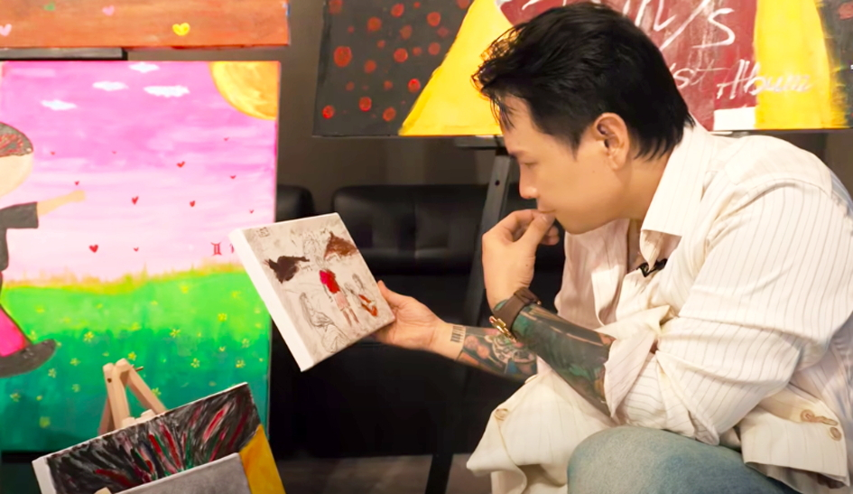Rapper Binz xem bức tranh được người hâm mộ vẽ lại sau khi nghe album mới của anh - Ảnh chụp từ clip