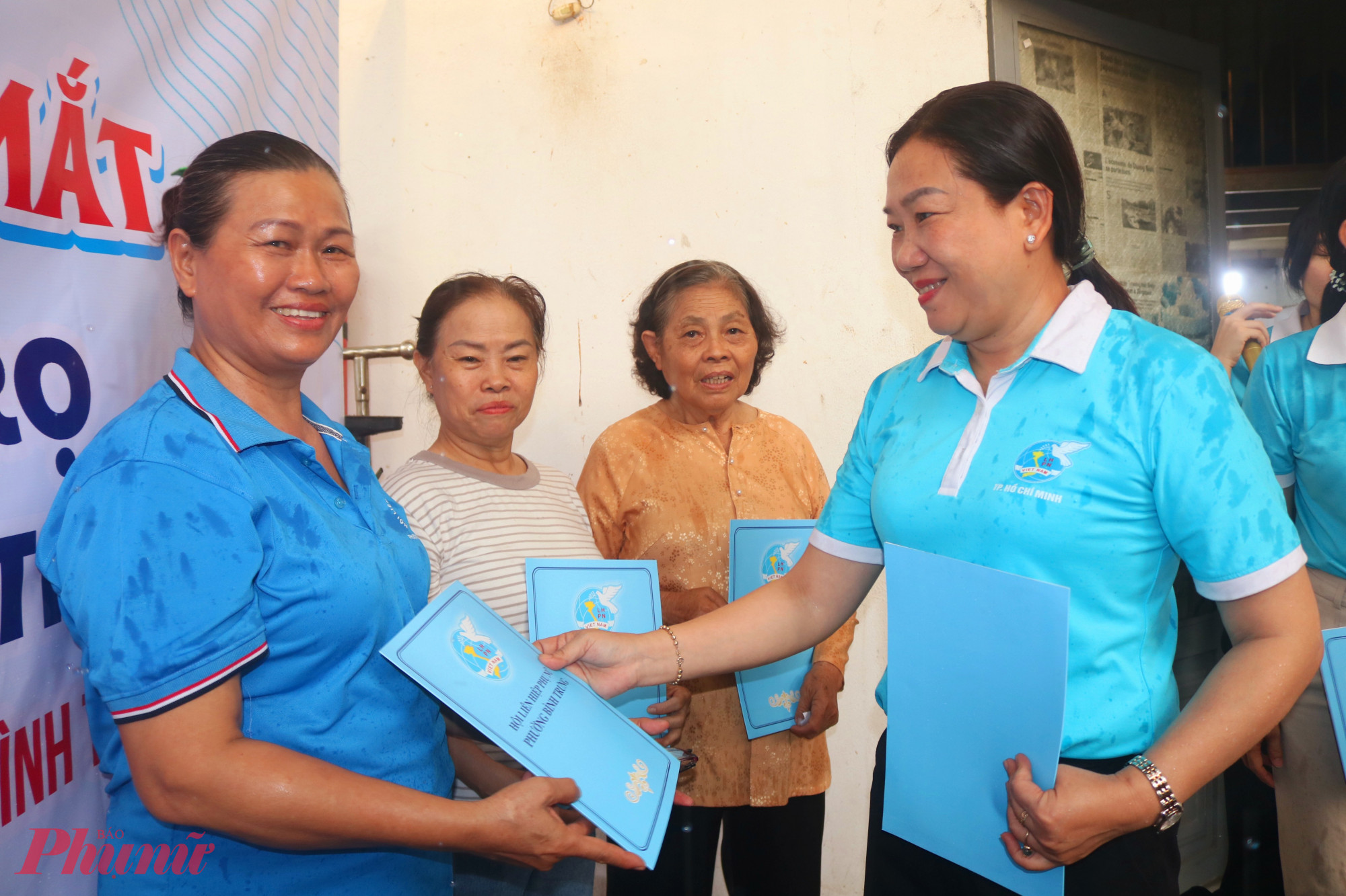 Bà Nguyễn Thị Tuyết Nga – Ủy viên Ban Thường vụ Hội LHPN TPHCM, Trưởng bộ phận Gia đình, dân số và trẻ em – trao quyết định thành lập “Tổ tự quản khu nhà trọ 3 an” đến các thành viên của tổ - Ảnh: Mẫn Nhi