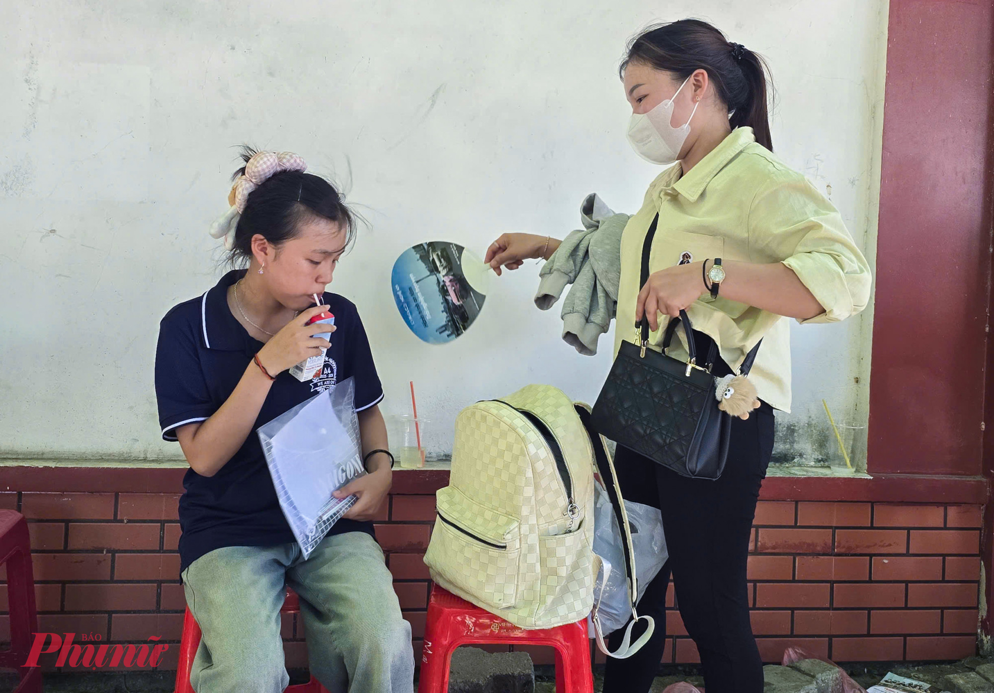 Giữa cái nắng bỏng rát, ngột ngạt, nhiều phụ huynh phải mang theo quạt tay, nước uống, khăn lạnh… để tiếp sức cho con trước và sau mỗi buổi thi.