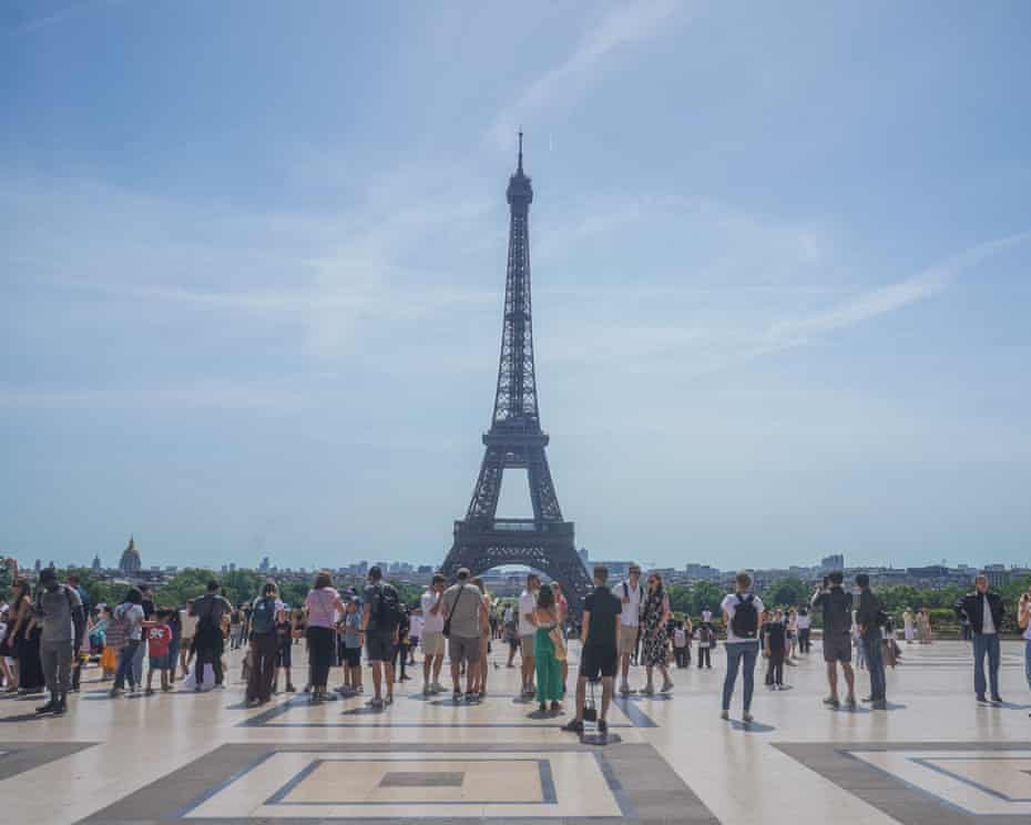 Du khách ngắm nhìn Tháp Eiffel từ Vườn Trocadero vào một ngày nắng nóng oi bức ở Paris, khi nhiệt độ lên tới gần 33 độ C - Ảnh: Amer Ghazzal