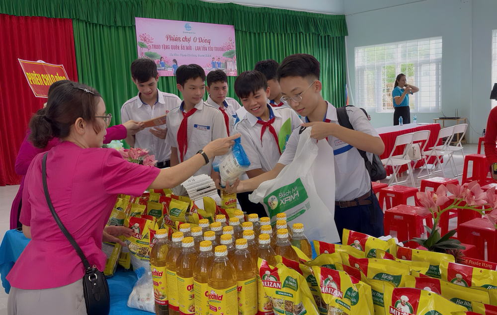 Các em học sinh nhận quà nhu yếu phẩm. Ảnh: TC