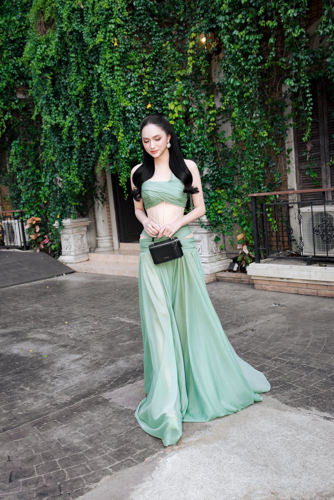 Hoa hậu mang đến phong cách nữ tính, quyến rũ với chiếc đầm màu xanh pastel của NTK Duy Trần. Trên tay Hương Giang là mẫu túi 