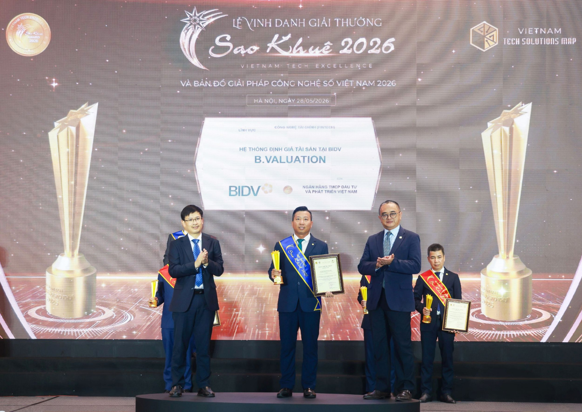Đại diện Lãnh đạo Trung tâm Định giá tài sản kiêm Lãnh đạo Ban QLDA Xây dựng phần mềm Hệ thống định giá tài sản tại BIDV lên nhận giải thưởng Sao Khuê 2026 với sản phẩm B.Valuation - Ảnh: BIDV