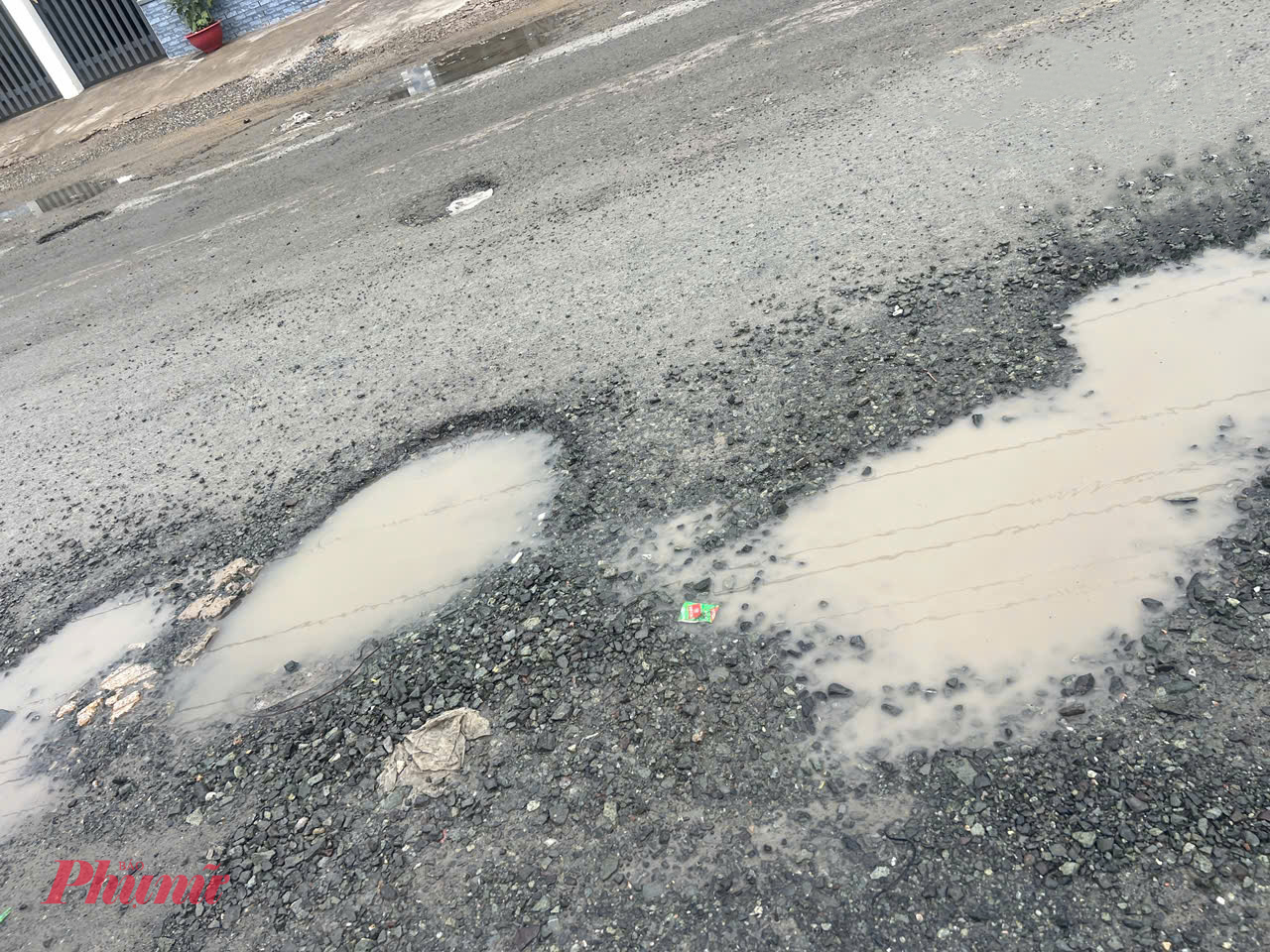 Các hố nước lớn nhỏ xuất hiện dày đặc trên đường Đinh Đức Thiện gây cản trở giao thông.