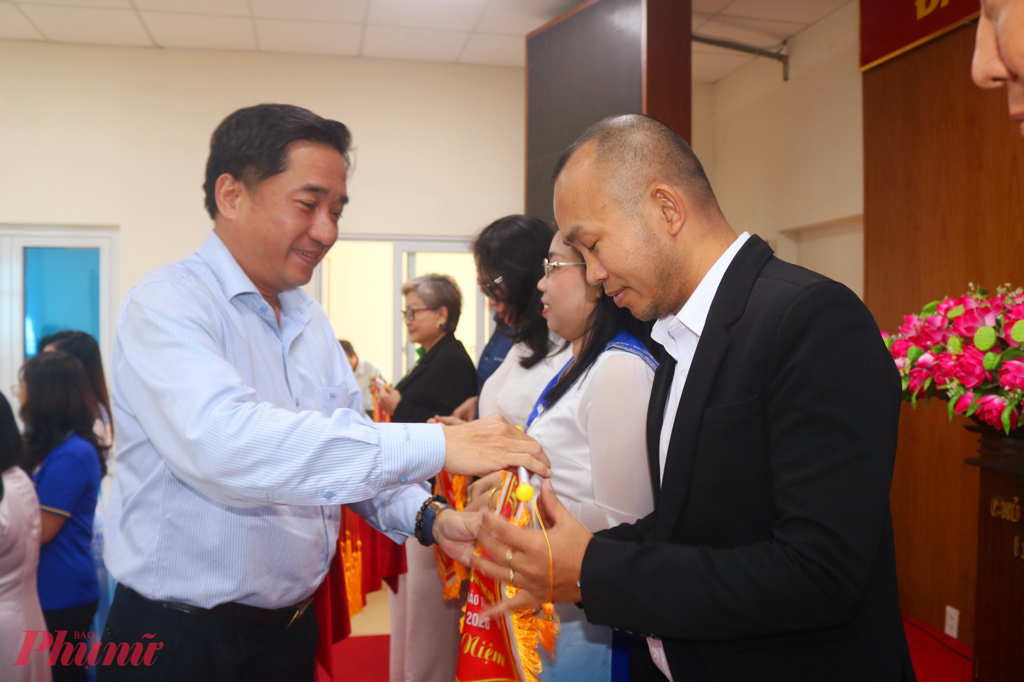 Ông Mai Tiến Dũng – Phó bí thư thường trực Đảng ủy phường Bình Hưng Hòa – trao cờ lưu niệm đến đại diện các đội tham gia liên hoan văn nghệ - Ảnh: Thảo Nguyên
