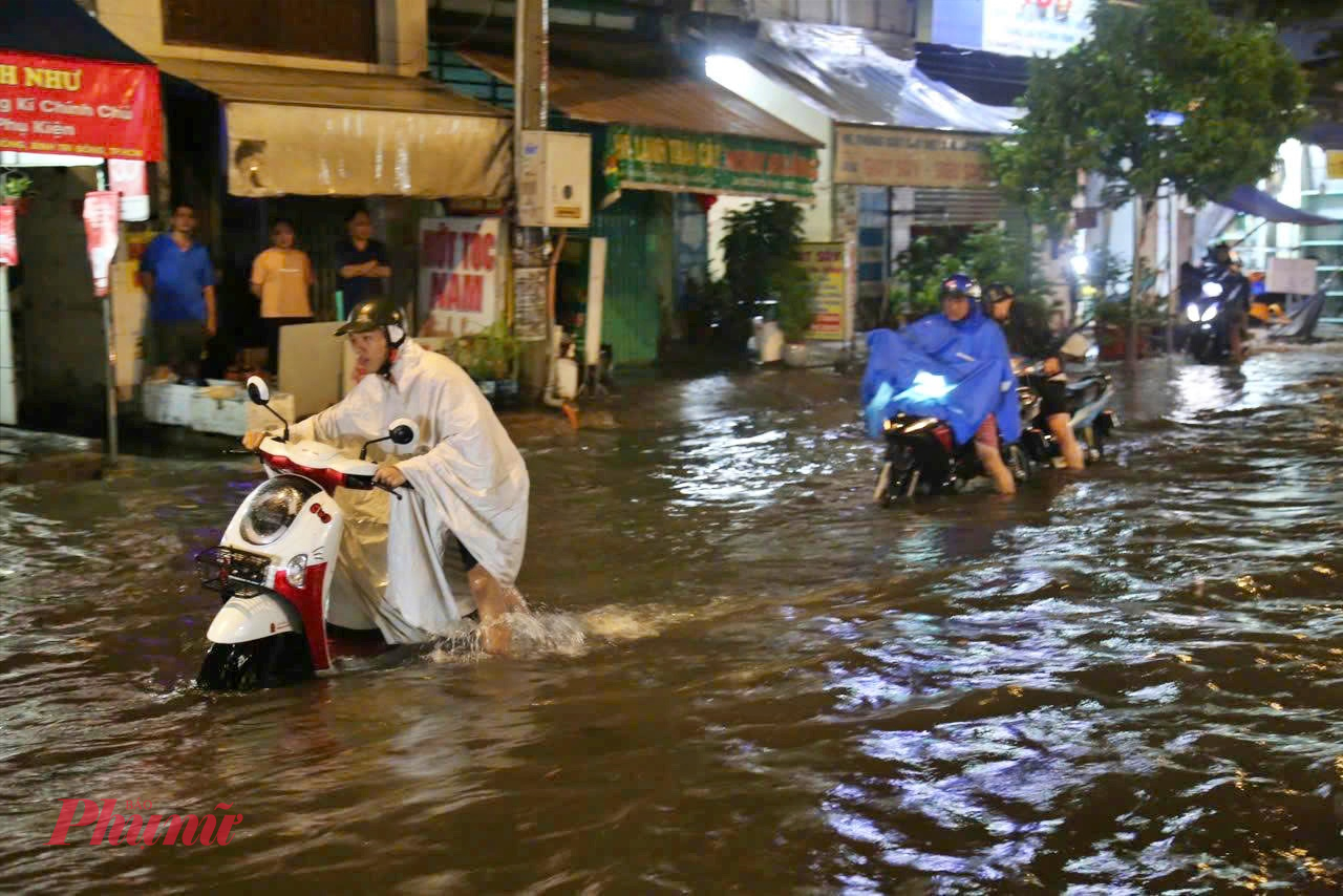 Trên đường Bình Trị Đông, dòng nước đục ngầu tràn kín mặt đường. Nhiều xe máy khi lưu thông qua khu vực đã bị chết máy giữa dòng nước, người dân phải xuống dắt bộ hàng trăm mét. 