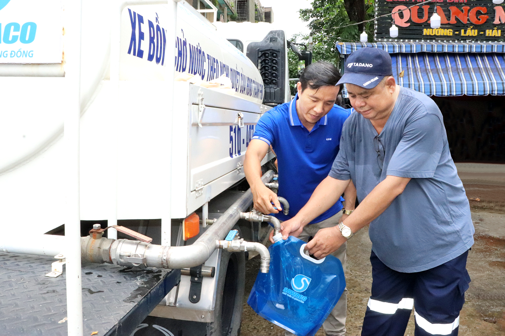 Đồng bộ giải pháp ứng phó xâm nhập mặn Người dân cư xá Thanh Đa nhận túi nước đề phòng sự cố mất nước diện rộng tại chương trình diễn tập - Ảnh: Đinh Bích