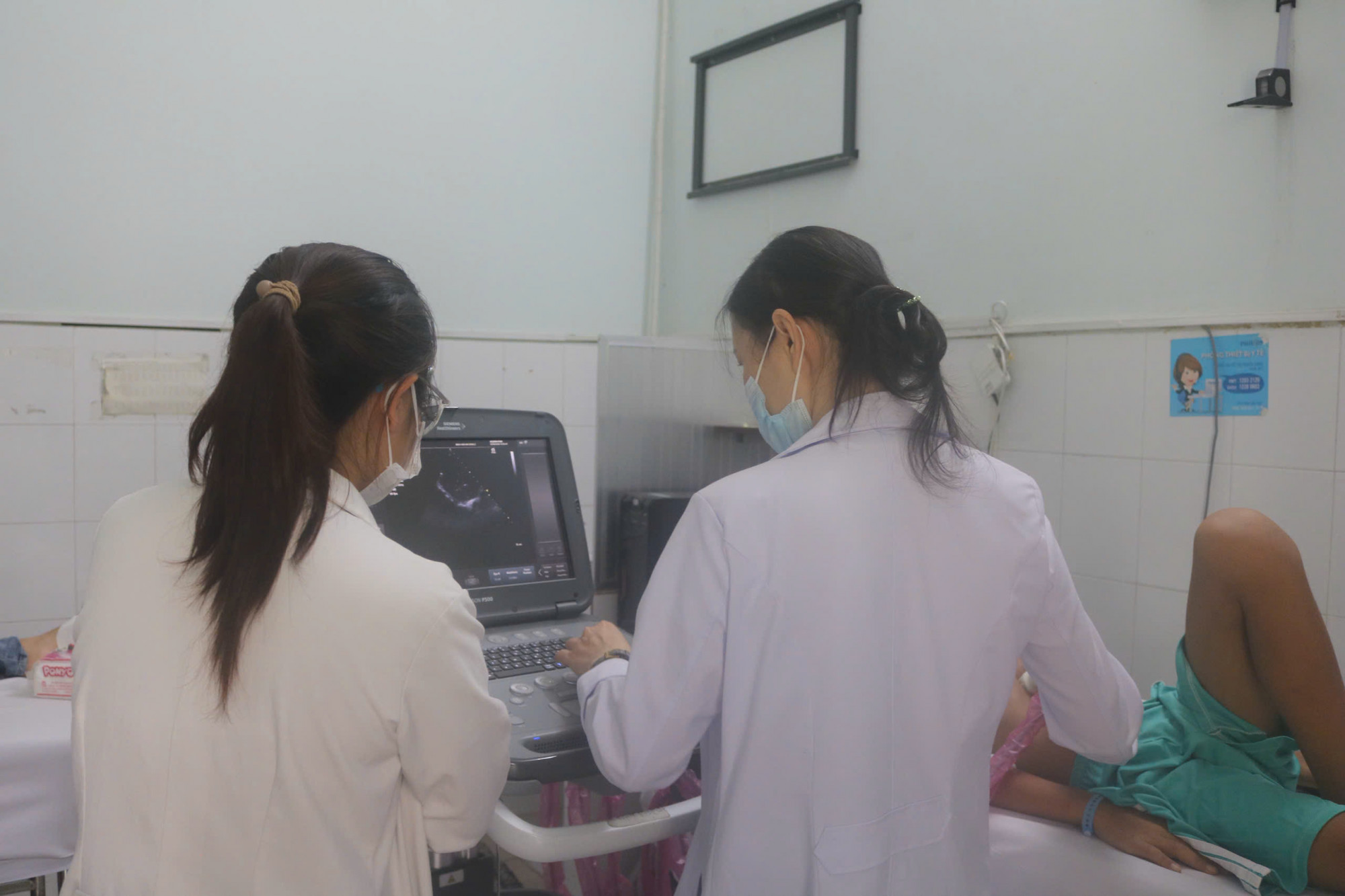 Bác sĩ siêu âm tim lại cho em K. sau phẫu thuật, ảnh BVCC