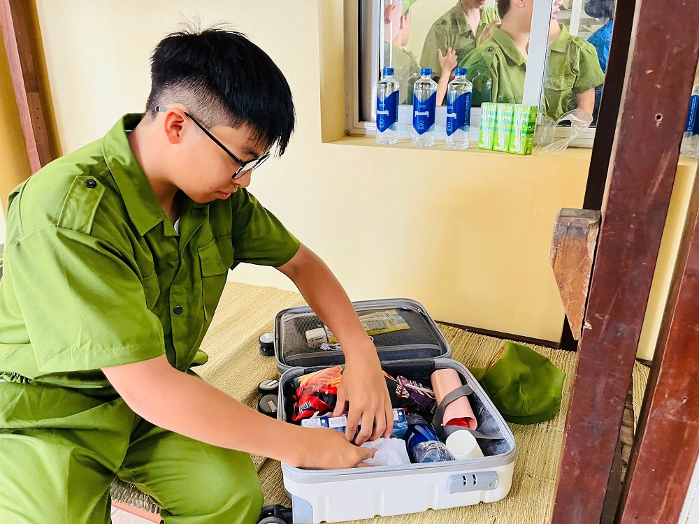 Phúc Khang học cách tự xắp xếp đồ dùng trong ngày đầu tham gia “Học làm chiến sĩ công an” - Ảnh: VN