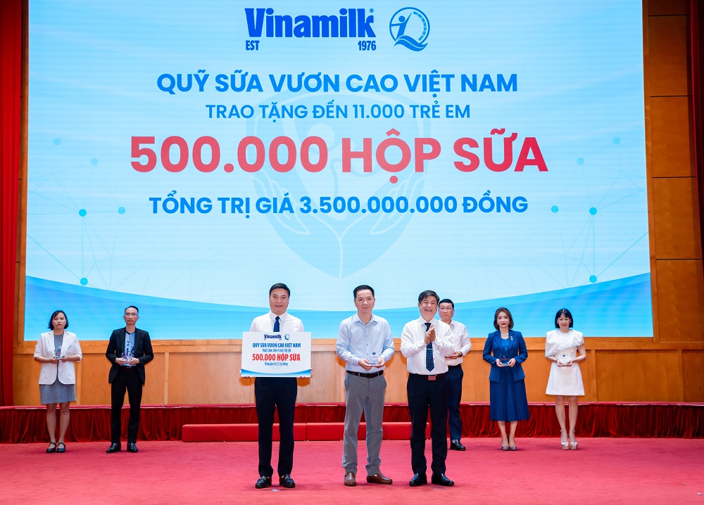 Đại diện Vinamilk (đứng giữa) trao bảng tượng trưng 500.000 hộp sữa và nhận kỷ niệm chương từ Bộ Y tế - Ảnh: VN