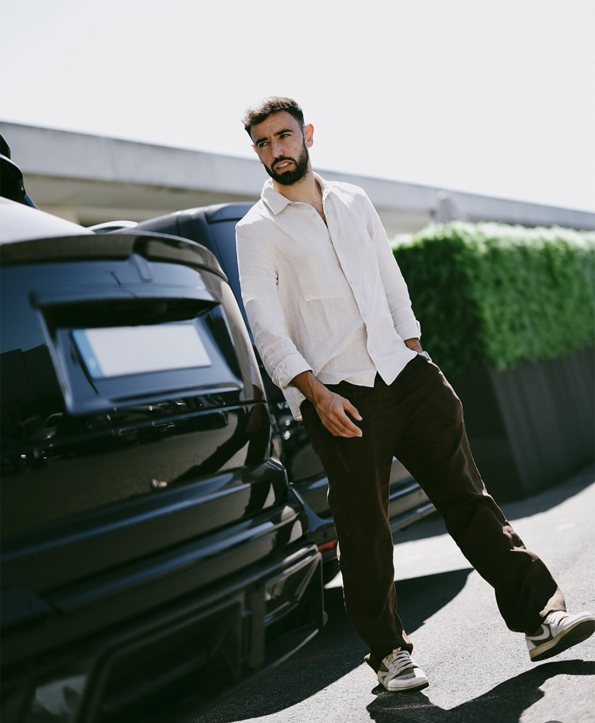 Bruno Fernandes chọn sơ mi linen trắng kết hợp quần tối màu và sneaker cổ thấp. Cách phối đồ mang tinh thần smart casual, cân bằng giữa sự lịch lãm và thoải mái. Chất liệu linen nhẹ nhàng cùng phom dáng rộng rãi đặc biệt phù hợp với thời tiết mùa hè và các chuyến di chuyển dài.