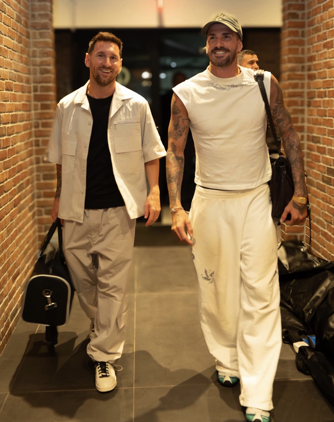 Lionel Messi xuất hiện với phong cách đời thường dễ ứng dụng gồm áo thun đen, sơ mi ngắn tay màu kem khoác ngoài và quần suông màu be. Bộ trang phục không quá cầu kỳ nhưng vẫn tạo cảm giác lịch lãm nhờ bảng màu trung tính hài hòa. Đây là phong cách đặc trưng của Messi trong nhiều năm qua: đơn giản, thực dụng nhưng luôn tinh tế.