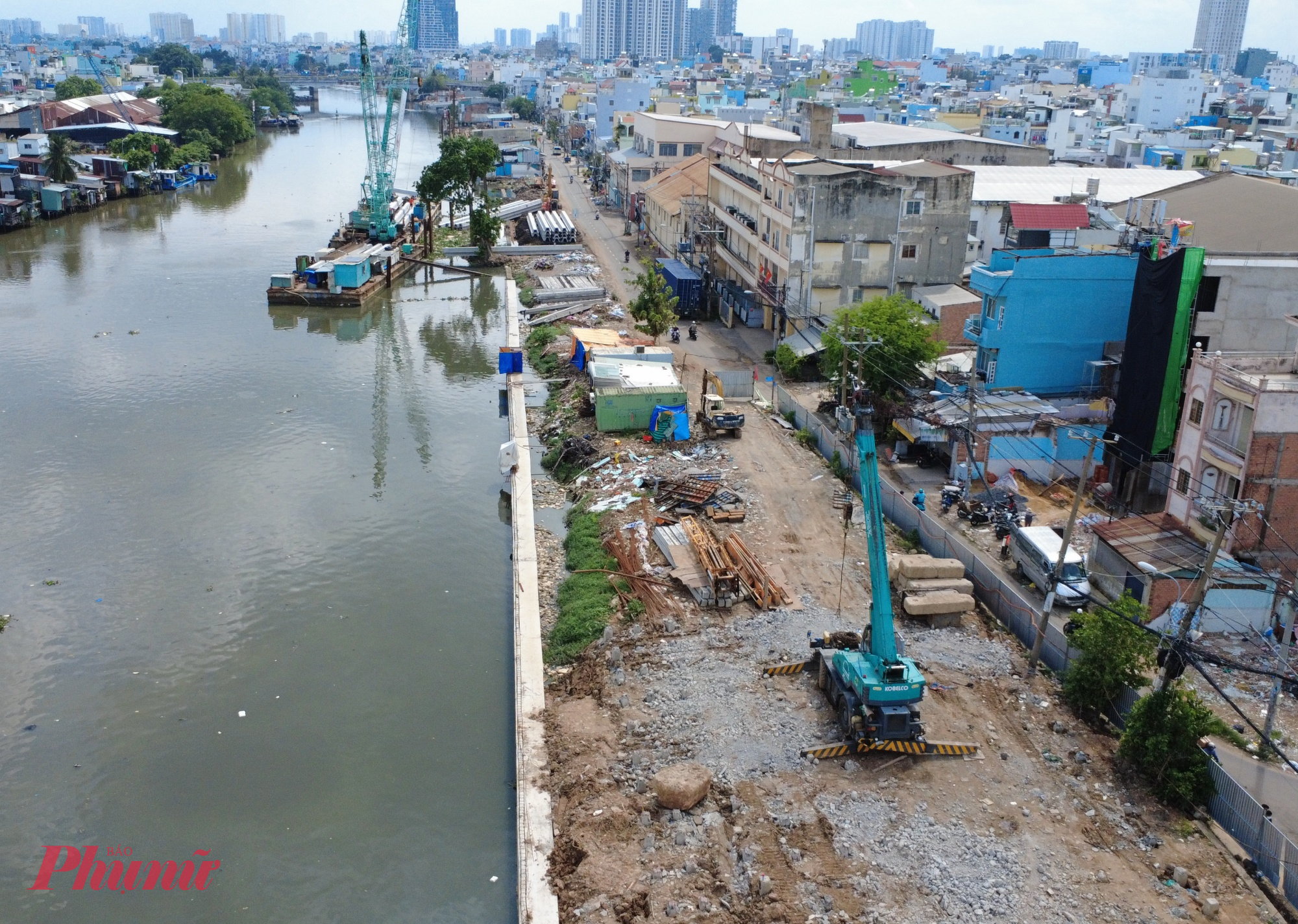 Trên công trường, hàng chục phương tiện cơ giới cùng công nhân đang khẩn trương triển khai các hạng mục kè bờ, san lấp mặt bằng và thi công hạ tầng kỹ thuật.
