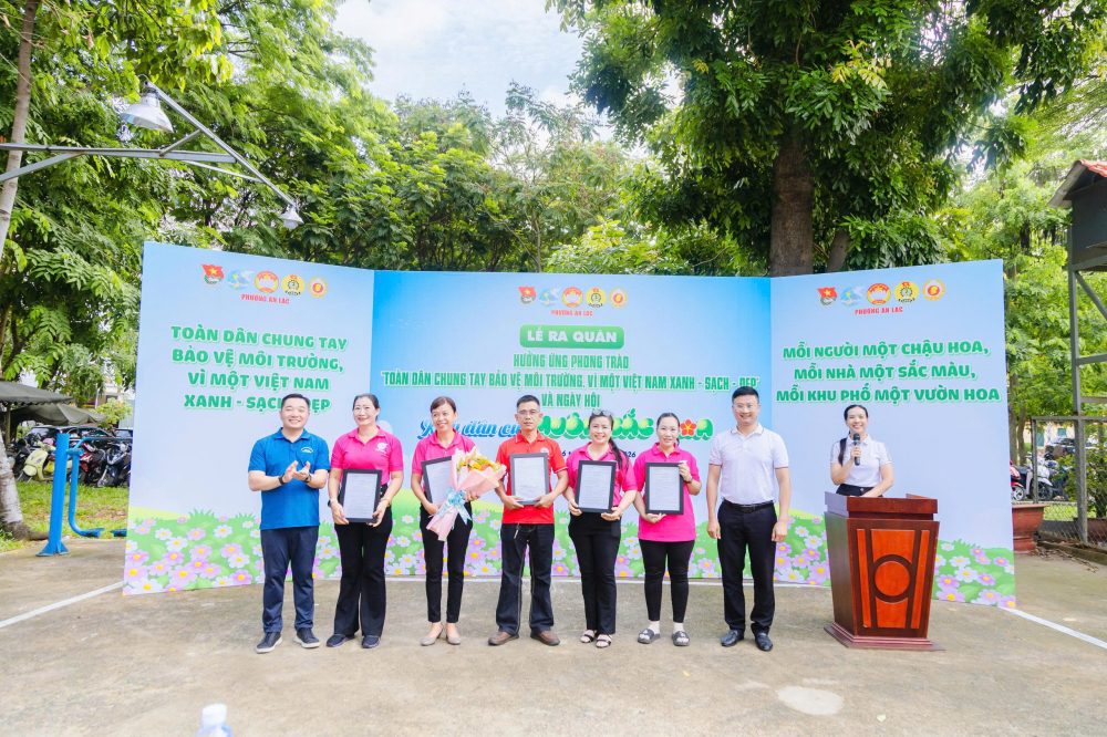Ông Lê Trương Hải Hiếu – Bí thư Đảng ủy, Chủ tịch HĐND phường An Lạc (bìa trái) và ông Lê Văn Trung – Chủ tịch Ủy ban MTTQ Việt Nam phường An Lạc (bìa phải) – trao quyết định thành lập CLB Vườn cộng đồng xanh An Lạc đến các thành viên trong ban chủ nhiệm - Ảnh: Ủy ban MTTQ Việt Nam phường An Lạc