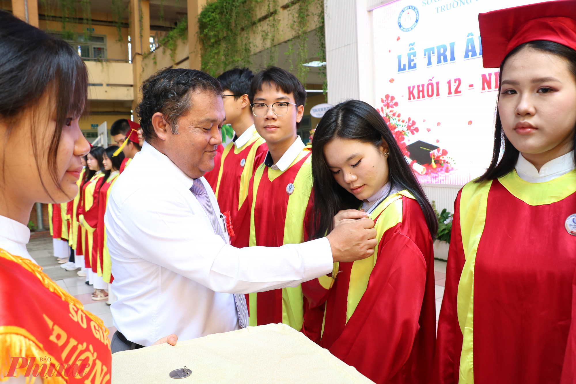 Ông Nguyễn Vân Yên - Hiệu trưởng nhà trường - trao huy hiệu trưởng thành cho học sinh