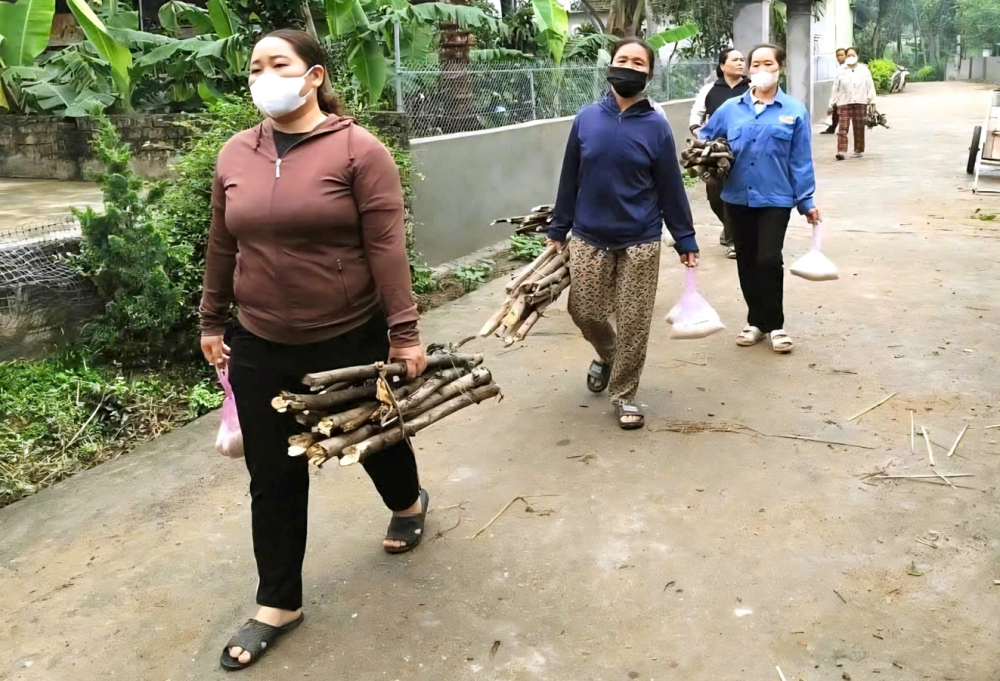 Phụ nữ thôn Vĩnh Thành, xã Thành Bình Thọ, tỉnh Nghệ An, mang củi, gạo đến hỗ trợ gia đình hội viên lo hậu sự