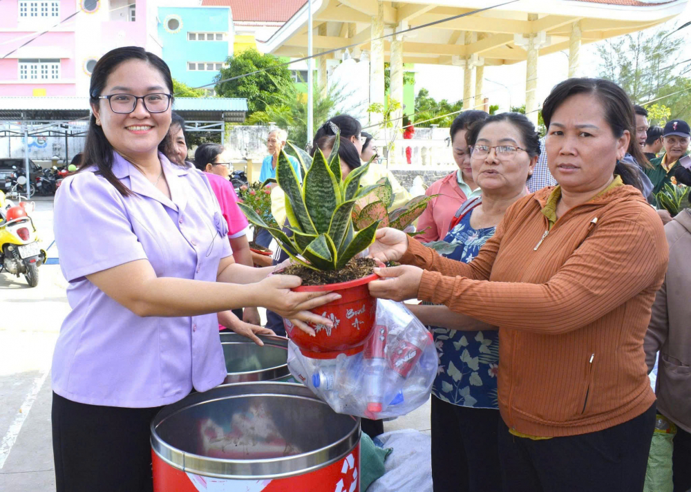 Bà Cao Thị Hạnh Nhung - Phó chủ tịch Uỷ ban MTTQ Việt Nam xã, Chủ tịch Hội LHPN xã Cần Giờ - trao cây xanh đến người dân. Ảnh: TP