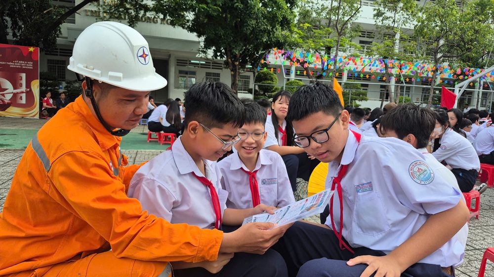 Nhân viên EVNSPC tuyên truyền, hướng dẫn các em học sinh thực hành các giải pháp tiết kiệm điện - Ảnh: EVNSPC