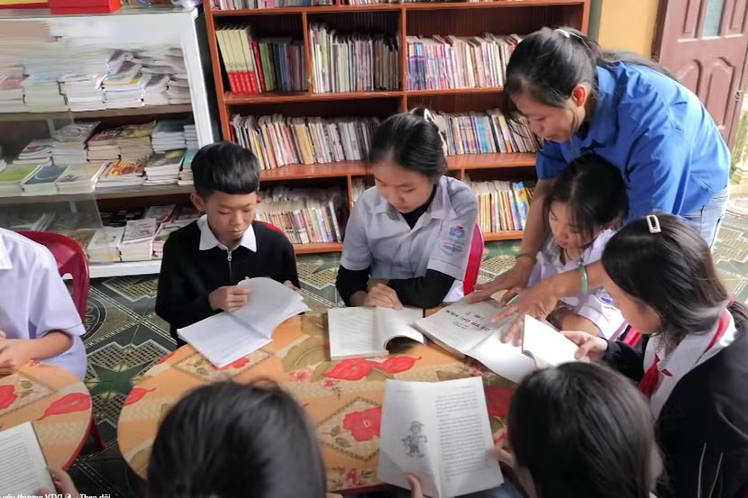 Chị Bùi Thị Hà với niềm vui thường nhật ở thư viện miễn phí chị lập ra cho trẻ em - Ảnh: THP