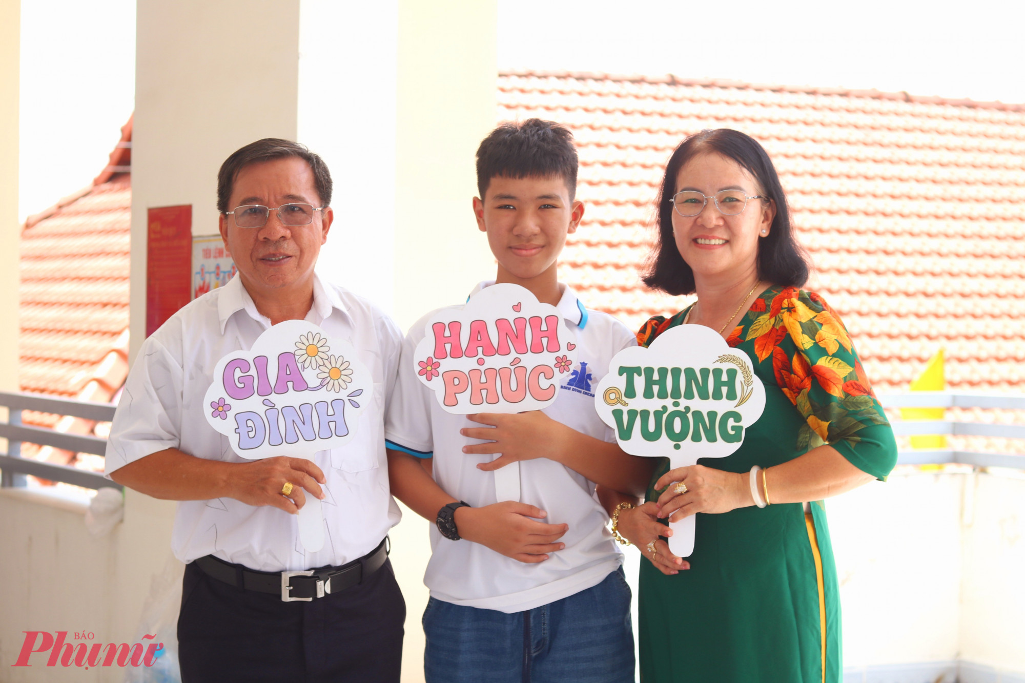 Vợ chồng chị Nguyễn Thị Bích Thủy – anh Nguyễn Văn Sơn và cậu con trai Nguyễn Hoàng Minh Khôi mang theo hashtag cầm tay để tạo không khí vui tươi cho hội thi - Ảnh: Mẫn Nhi