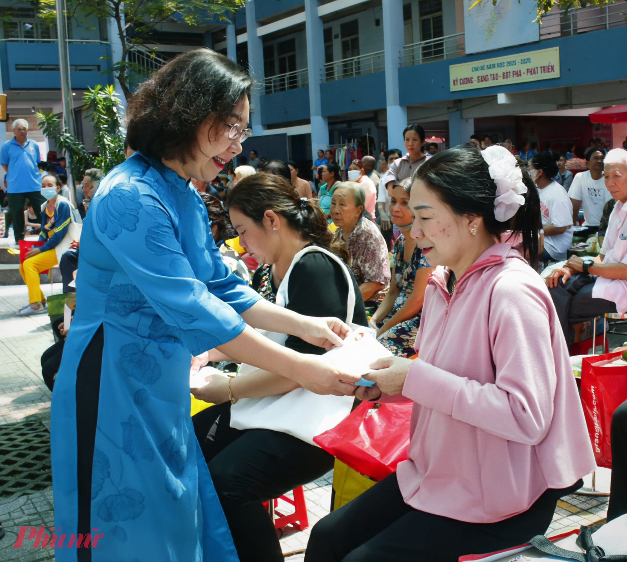Hàng Thị Thu Nga - Bí thư Đảng ủy, Chủ tịch Hội đồng nhân dân phường Tân Thuận - trao quà đến phụ nữ khó khăn.