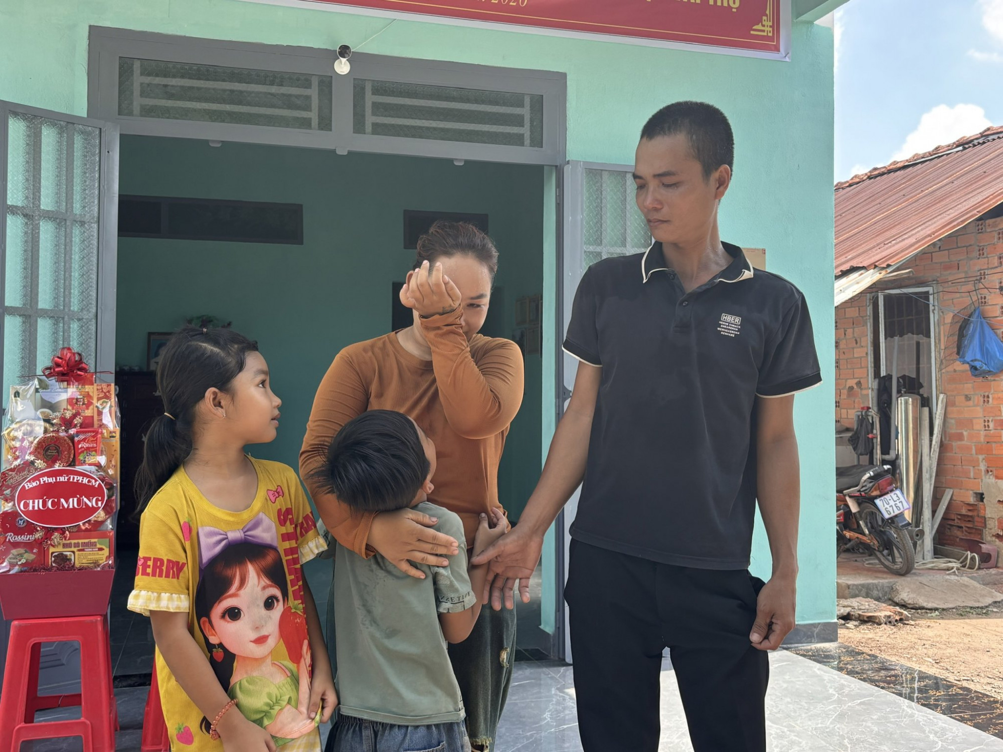 Niềm vui xen lẫn sự xúc động cũa gia đình chị Huỳnh Như trong ngày được tặng nhà. Ảnh Thùy Dương