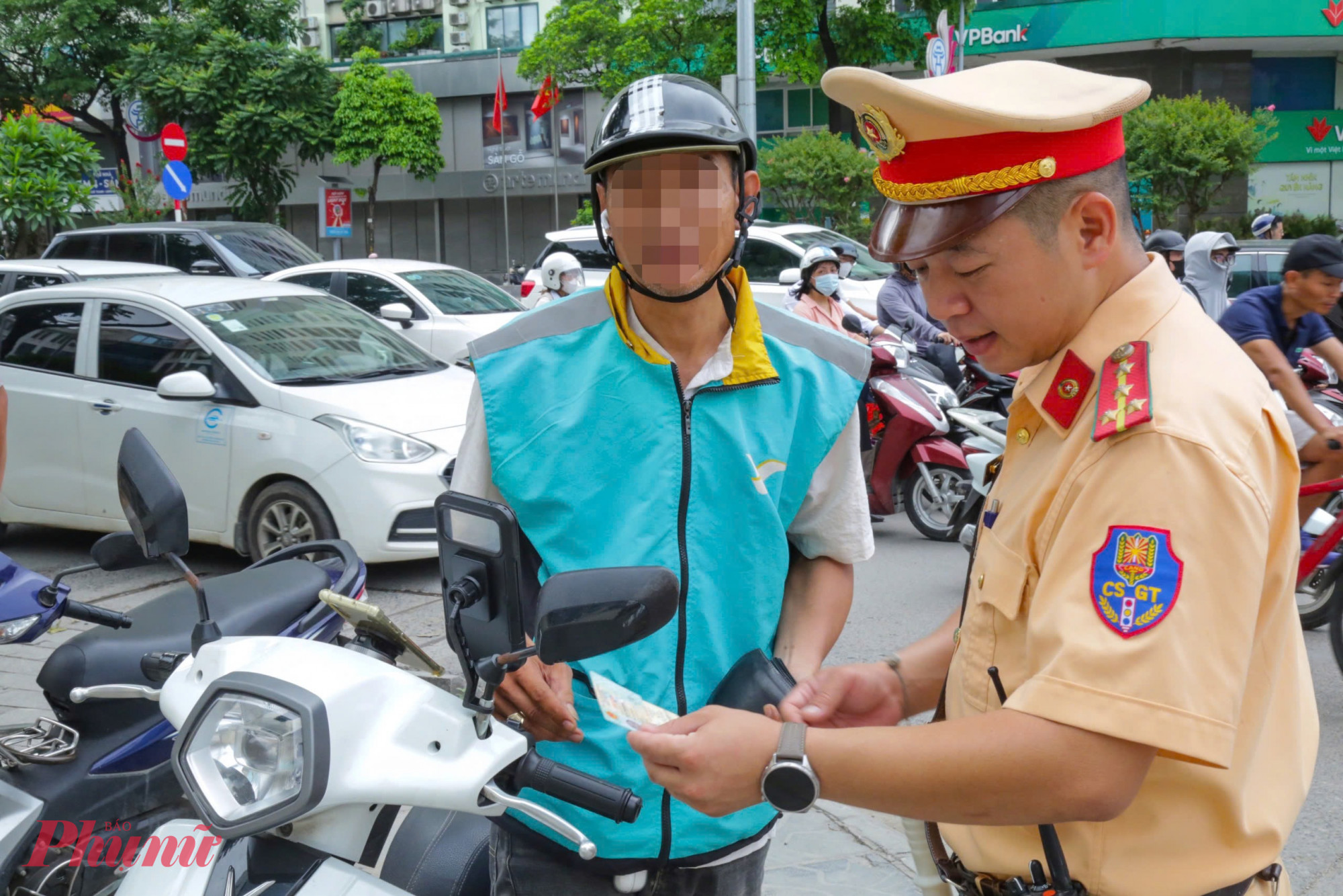 Tôi đeo tai nghe để tiện liên lạc với khách, nhiều lúc phải cầm điện thoại cũng rất bất tiện. Tôi không biết việc đeo tai nghe như này cũng vi phạm giao thông, ông T. nói và bị CSGT lập biên bản xử phạt.