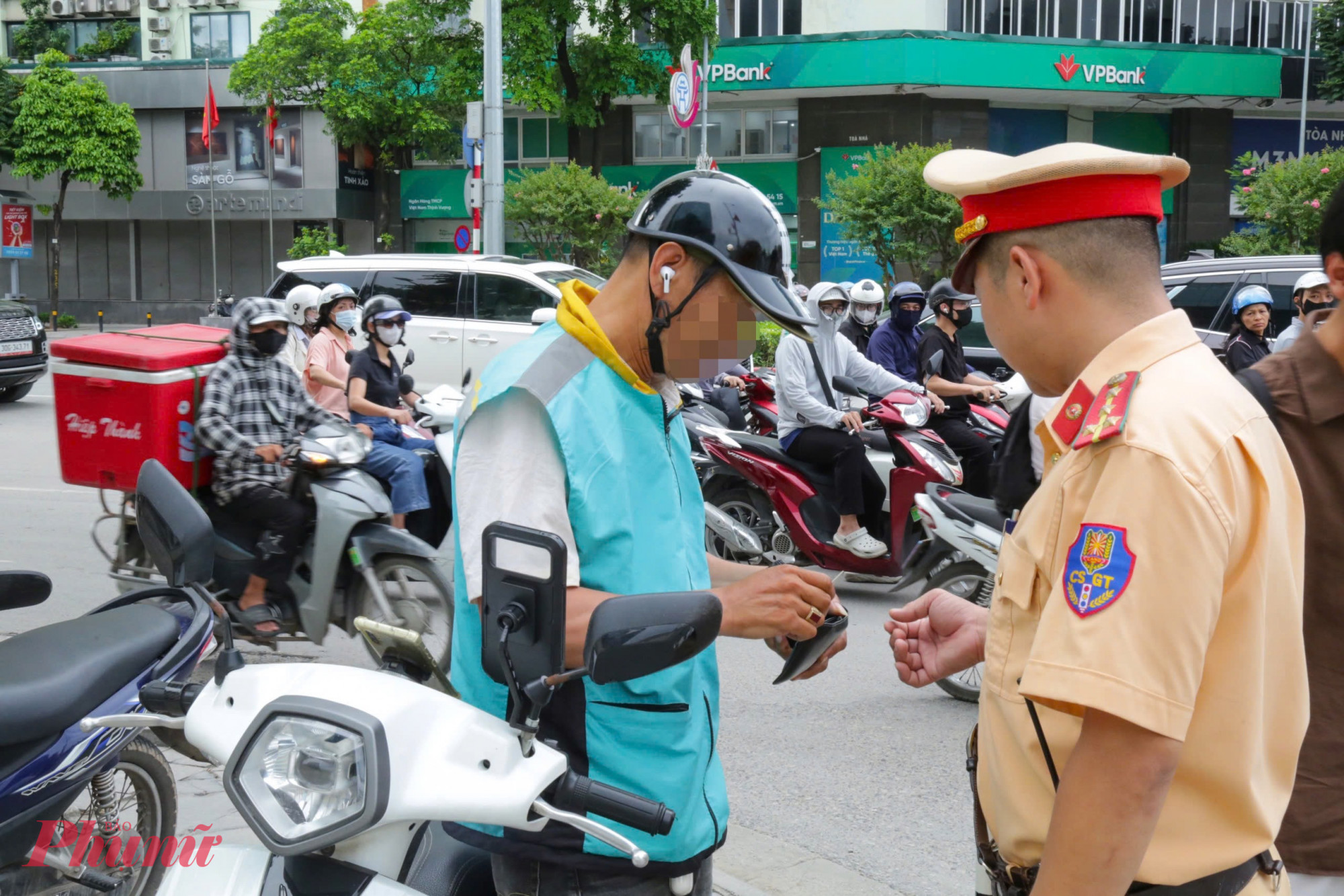 Khoảng 7g, tổ CSGT phát hiện lái xe ôm công nghệ Đ.Q.T. (SN 1974, ở Hà Nội) điều khiển xe máy chở theo khách phía sau nhưng nam tài xế này lại đeo tai nghe, nên dừng xe xử lý.