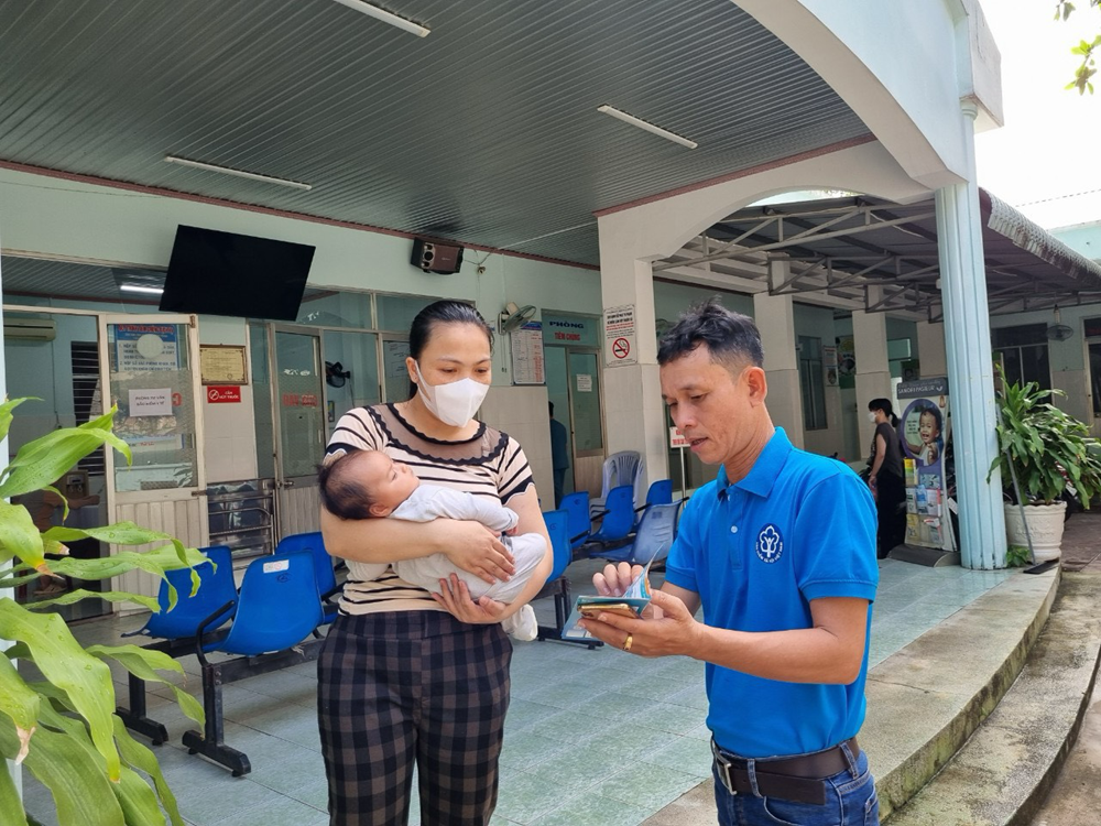 Nhân viên BHXH đang tư vấn BHYT cho người dân