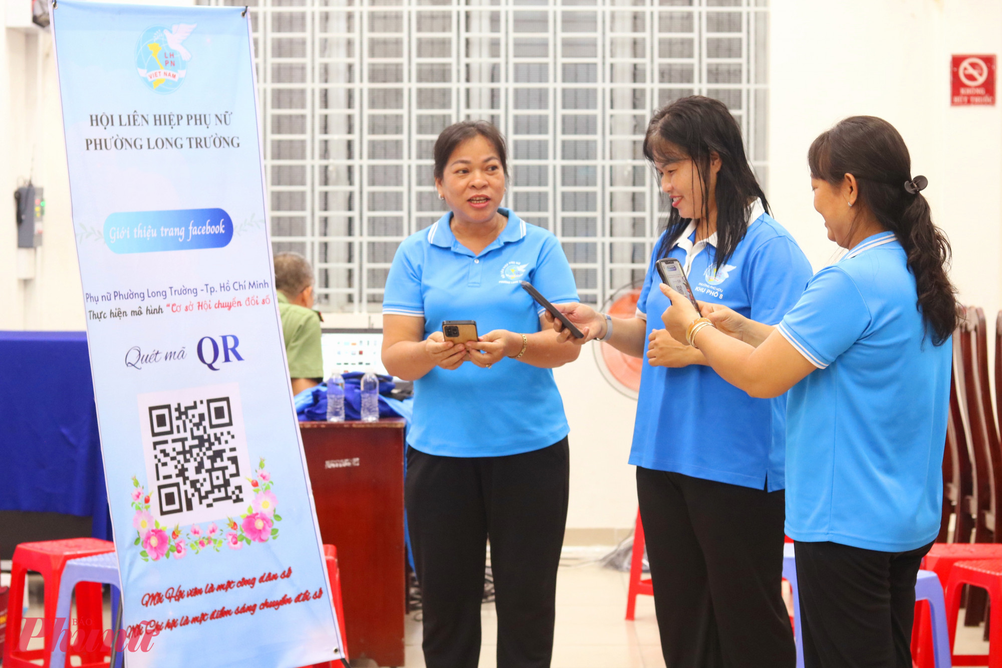 Các dì, các chị cùng quét mã QR tích hợp đường dẫn đến trang fanpage facebook Hội LHPN phường Long Trường - Ảnh: Mẫn Nhi