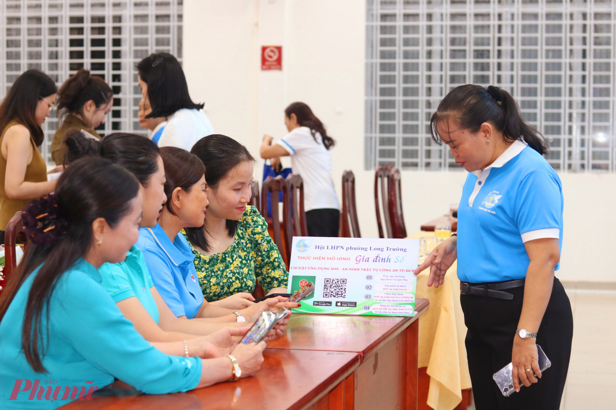 Các chị em cùng trao đổi với nhau về cách cài đặt ứng dụng SOS An ninh trật tự - Công an TPHCM - Ảnh: Mẫn Nhi 