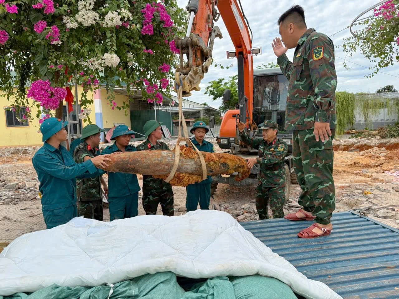 Lực lượng chức năng di dời quả bom đi tiêu hủy - Ảnh: Khánh Trung