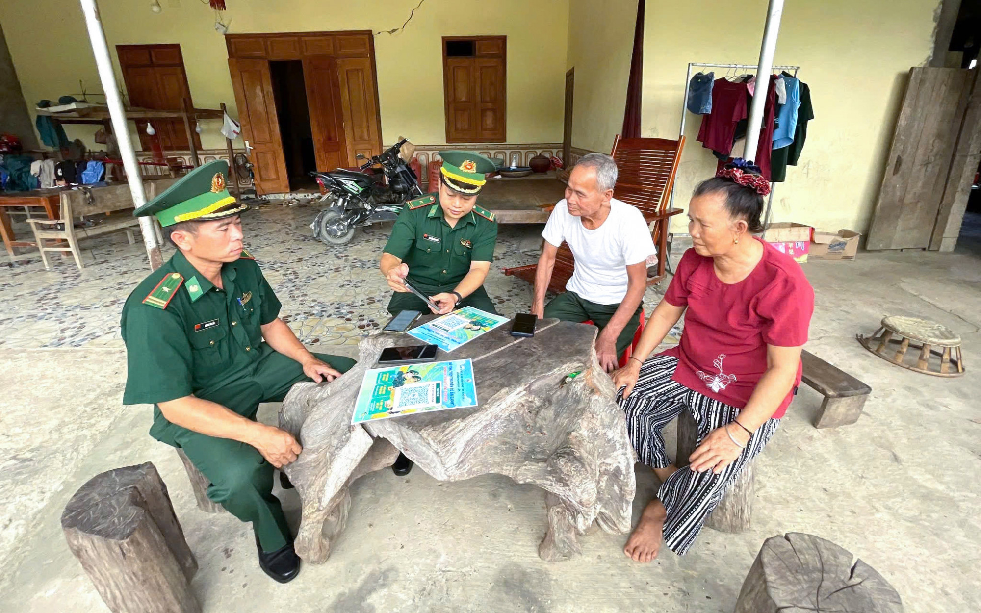 Cán bộ biên phòng đến tận nhà hướng dẫn người dân cung cấp thông tin phản ánh qua mã QR - Ảnh: Khánh Trung