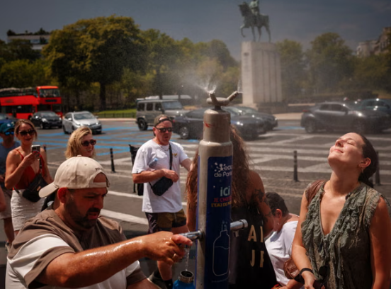 Mọi người giải nhiệt tại đài phun sương ở Place du Trocadero ở Paris vào thứ Sáu. Ảnh: Dimitar Dilkoff / AFP / Getty Images