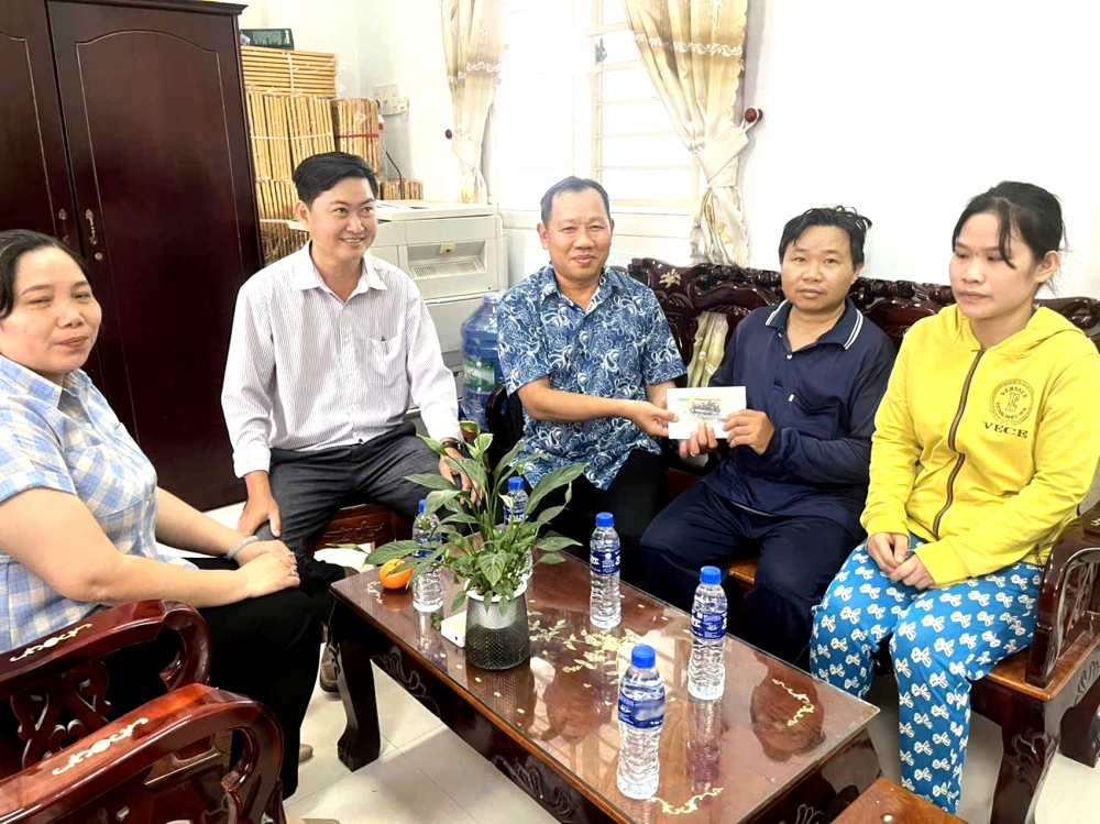 Nhà báo Huỳnh Lợi (giữa) - Trưởng văn phòng đại diện Vùng miền, Báo Phụ nữ TPHCM - trao tiền do bạn đọc hỗ trợ bé Nguyễn Minh Khang (xã Cái Nhum, tỉnh Vĩnh Long) điều trị bệnh - ẢNH: HUỲNH TRỌNG
