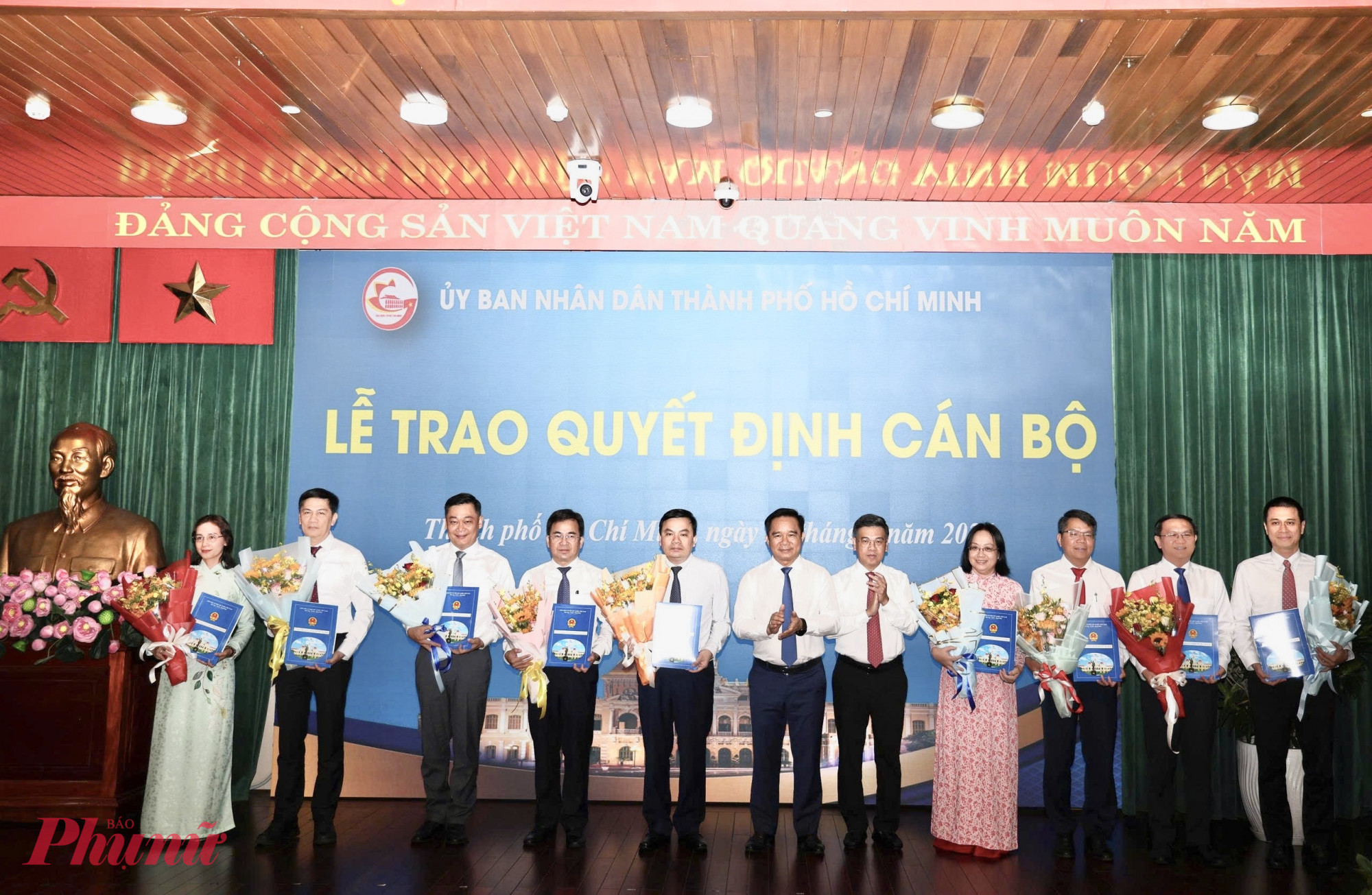 Chủ tịch UBND TPHCM Nguyễn Văn Được trao quyết định điều động công chức, Phó Chủ tịch HĐND TPHCM Nguyễn Văn Dũng tặng hoa chúc mừng các cán bộ nhận nhiệm vụ mới - Ảnh: T.T