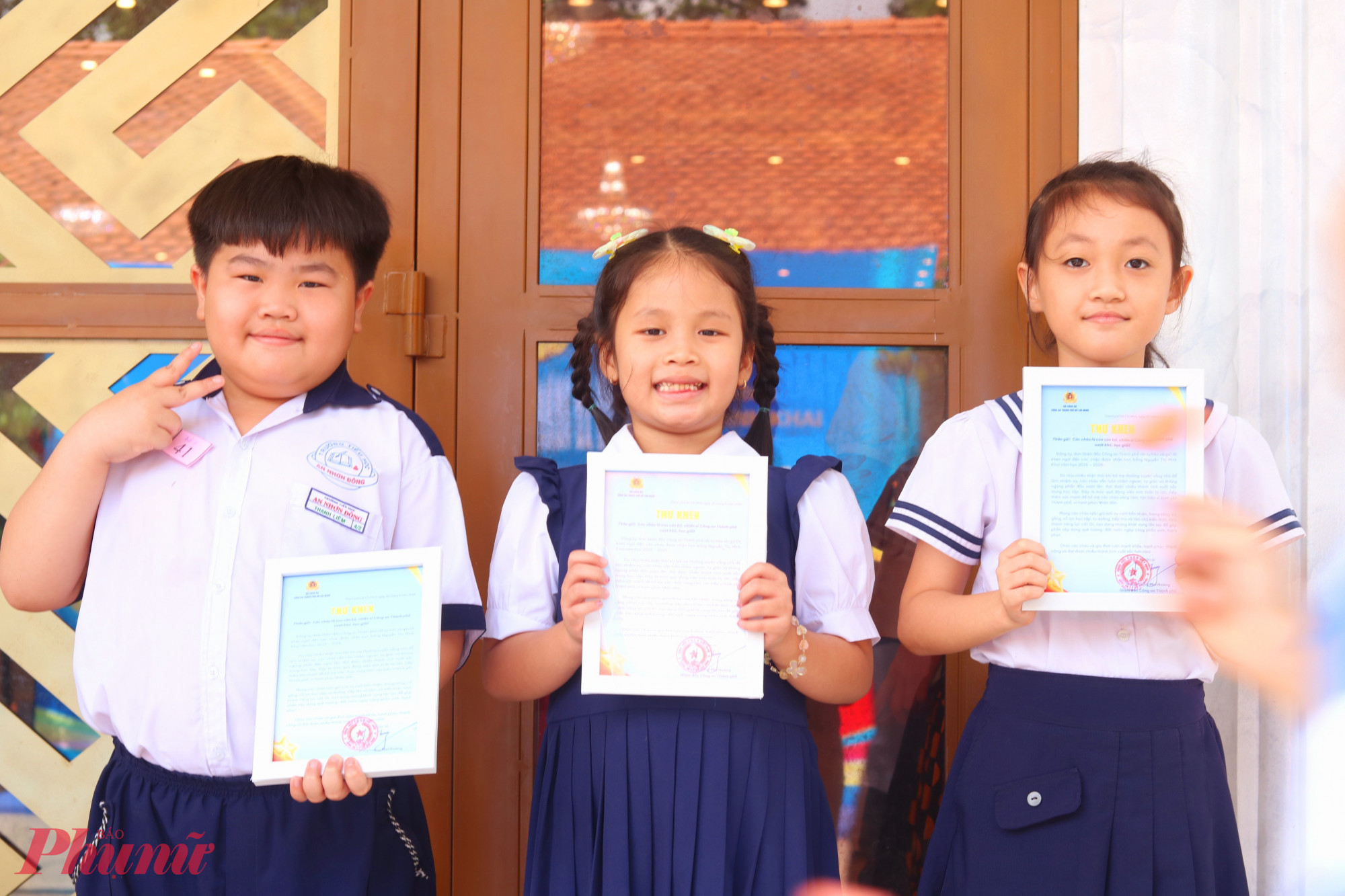 Các em học sinh phấn khởi khoe thư khen của Ban Giám đốc Công an TPHCM - Ảnh: Mẫn Nhi