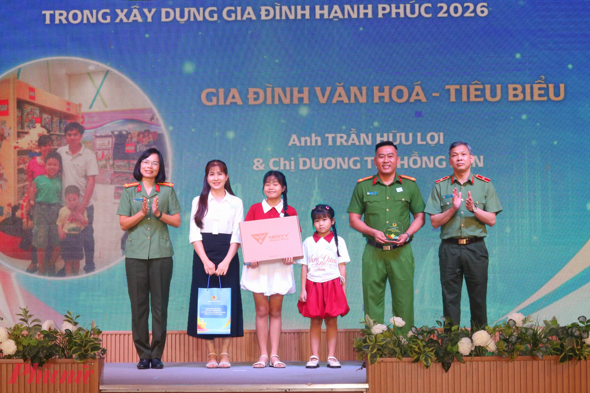 Thiếu tướng Tạ Văn Đẹp (bìa phải) và thượng tá Nguyễn Thị Quế (bìa trái) trao quà đến các gia đình được tuyên dương - Ảnh: Mẫn Nhi
