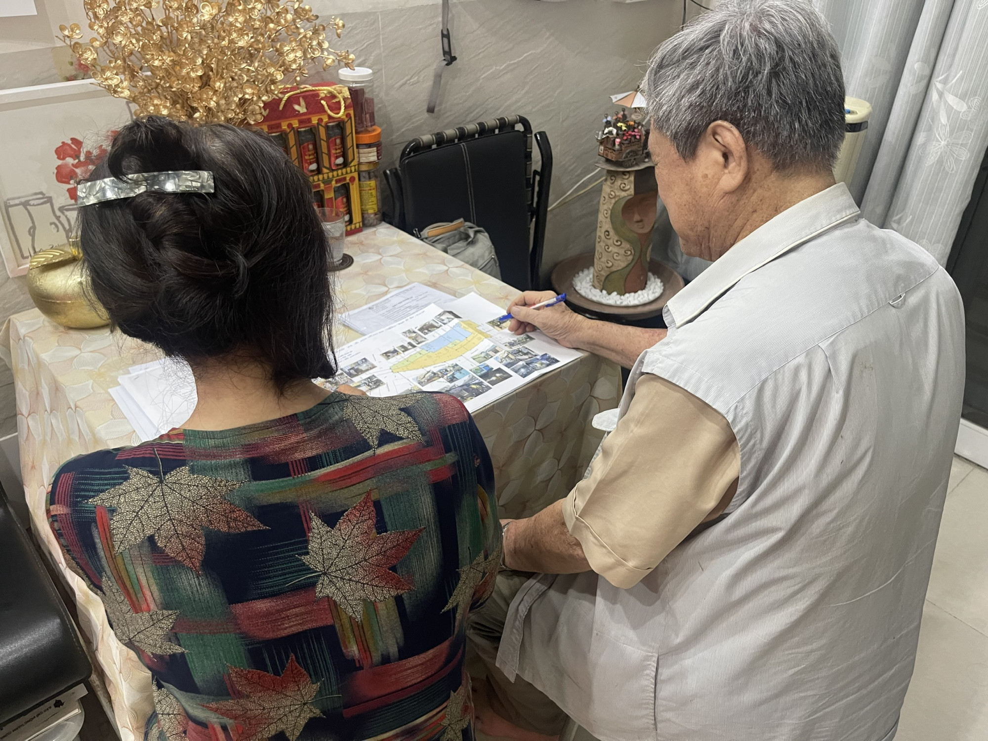 Vợ chồng ông T.V. bên đống đơn từ, hồ sơ chồng chất - Ảnh: DIệu Hiền